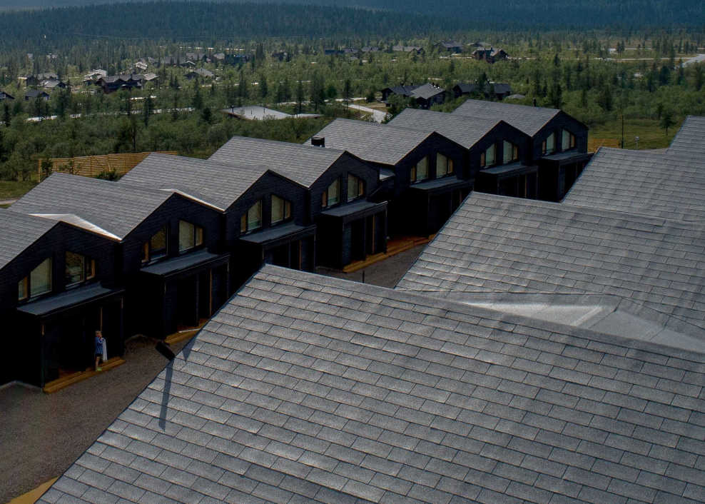 BMI Icopal bitumena šindeļu ilustratīvs attēls - jumtu ainava ar vairākām mājām