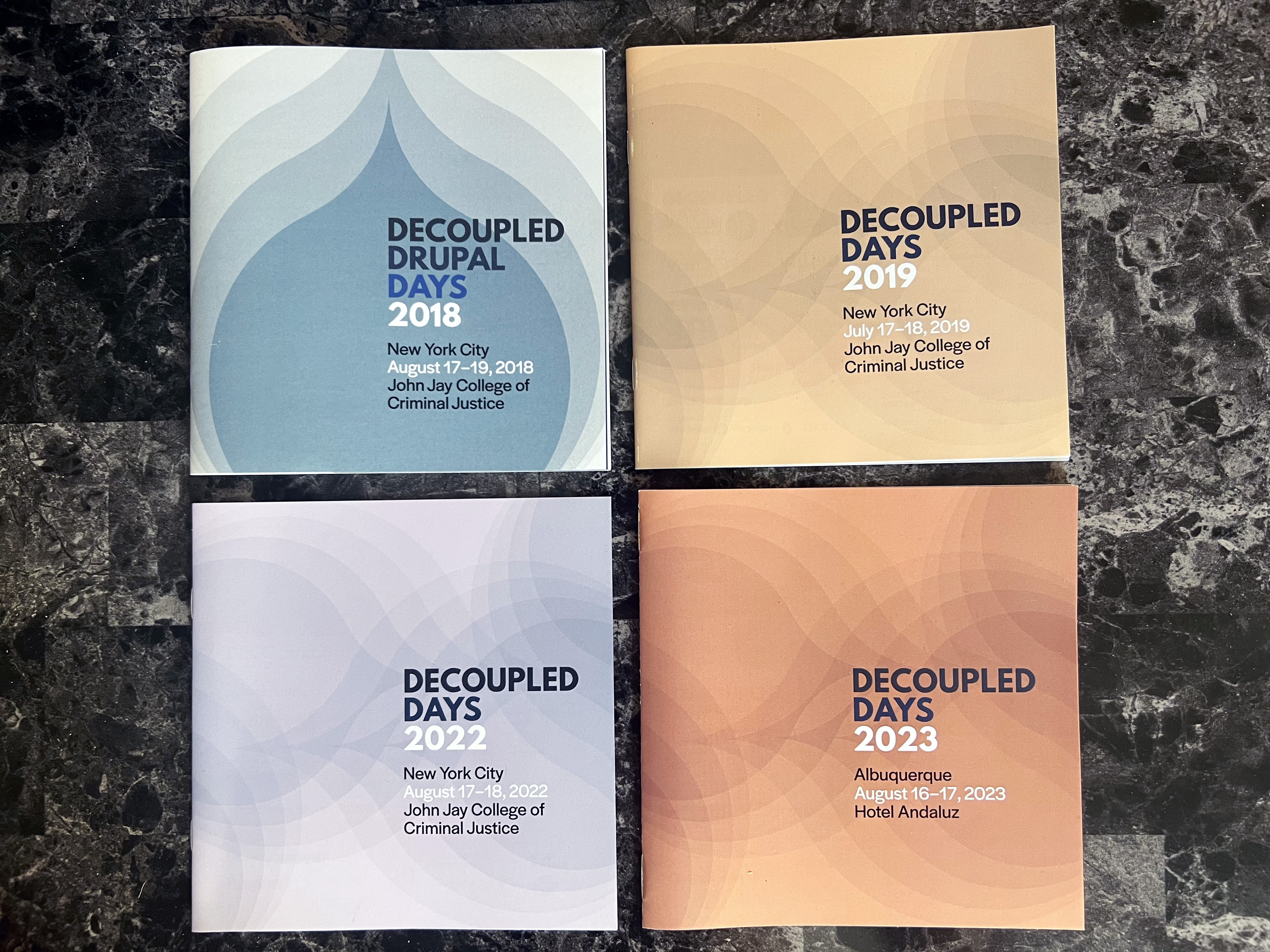 A collection of Decoupled Days’ printed programs from the 2018, 2019, 2022, and 2023 editions.