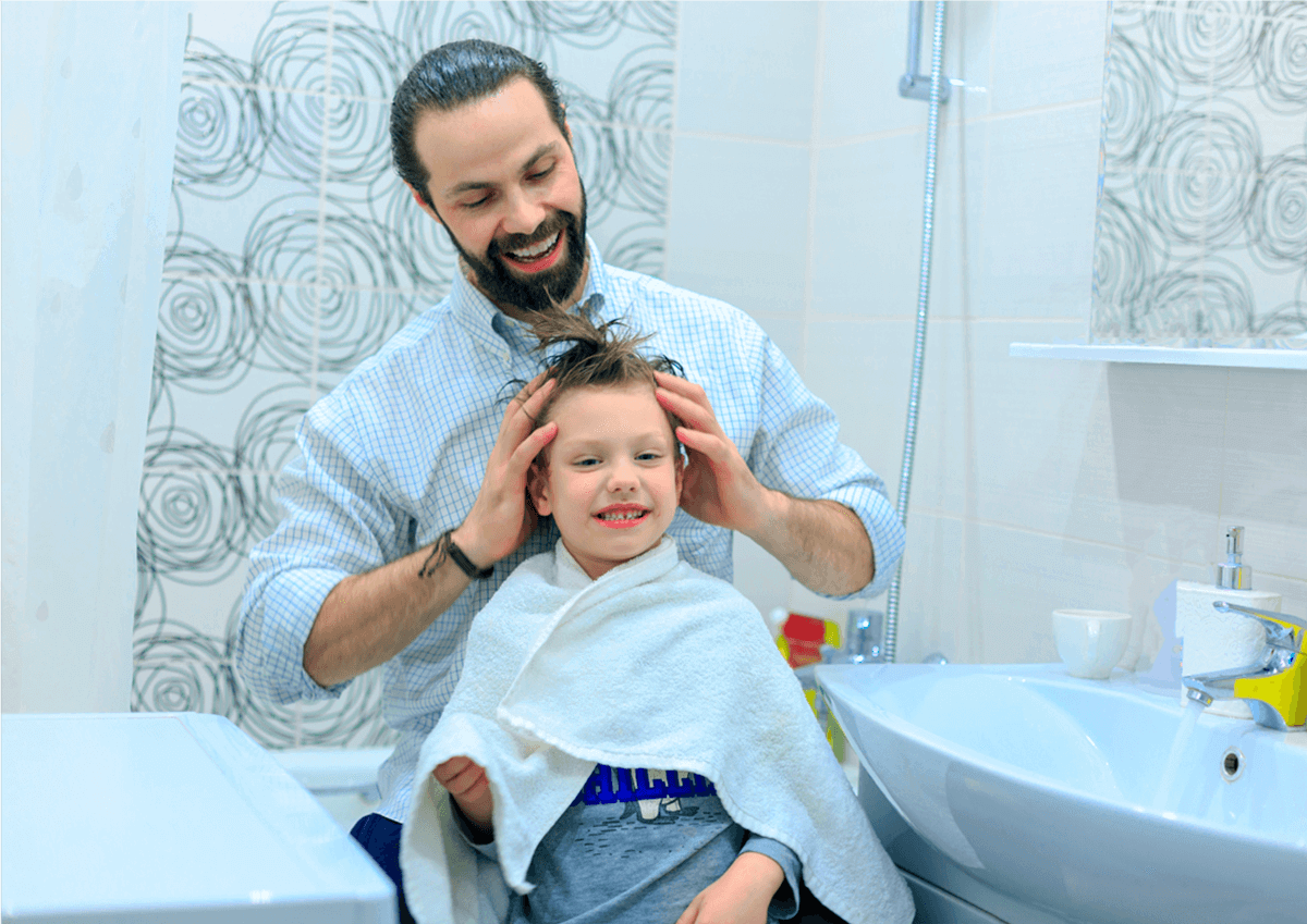 Papá se ríe con su hijo al peinarle el pelo