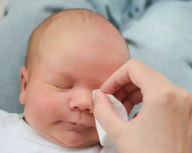 Madre limpiando cara del bebé