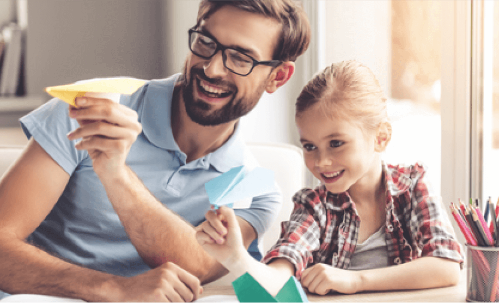 Padre e hija armando aviones de papel