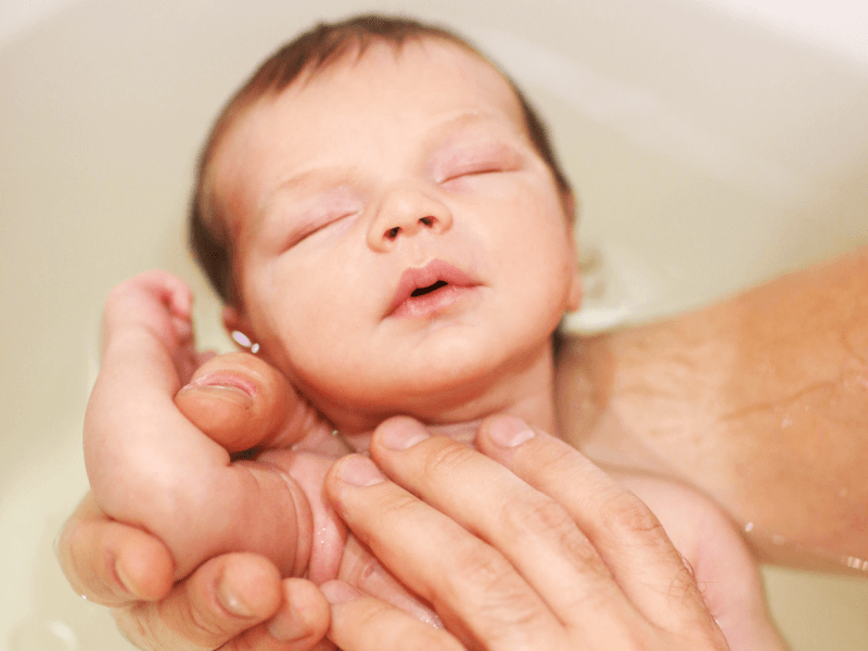 Padre dando un baño a su bebé