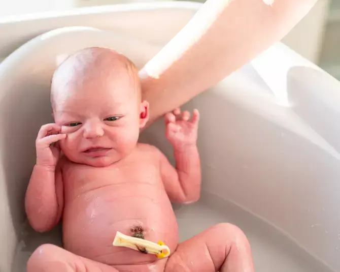 Madre limpiando cordón umbilical de su bebé