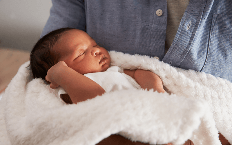 Recién nacido durmiendo en los brazos de mamá