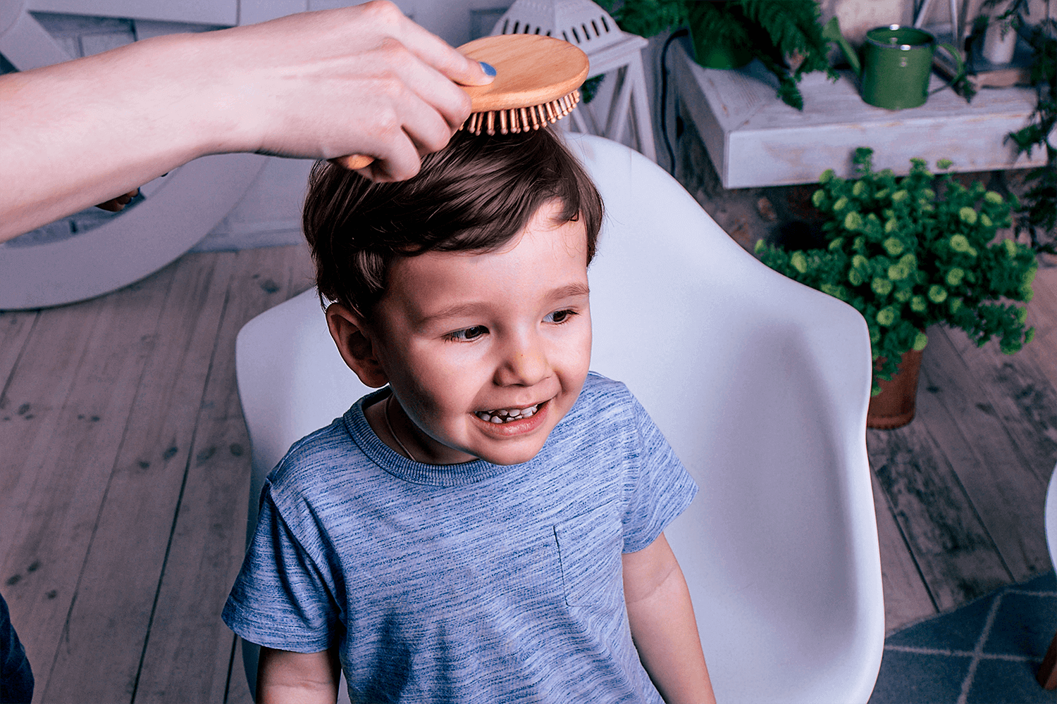 Niño sonriendo mientras le peinan