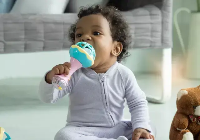 Bebé sosteniendo una maraca como parte de su motricidad fina