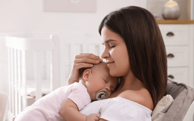 Bebé durmiendo en brazos de su madre