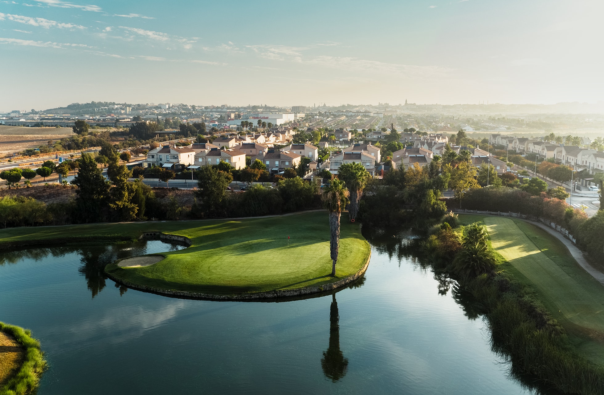 Luftfoto av golfbanen med flere vannhinder og grønne fairways