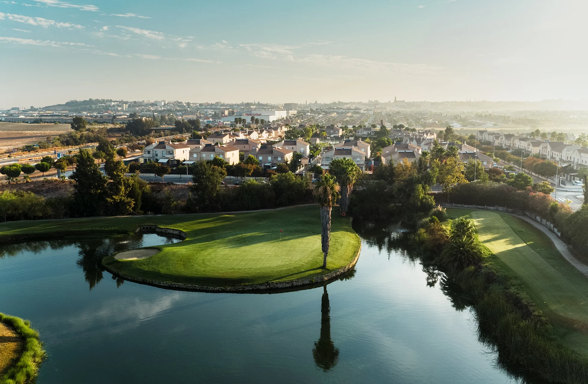 Luftfoto av golfbanen med flere vannhinder og grønne fairways