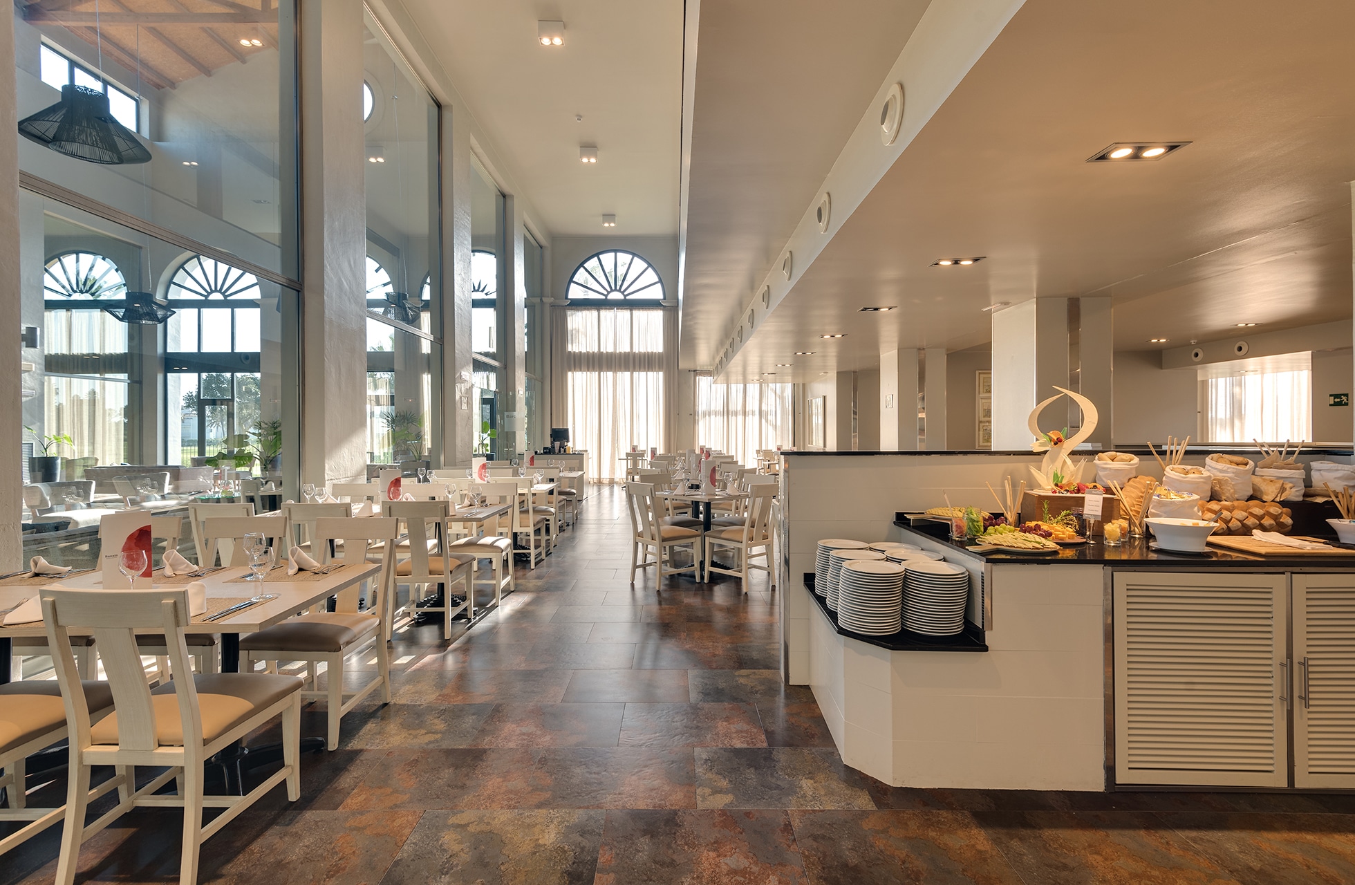 Restaurant med buffé, serveringsretter og dekket bord på Barcelo-Costa-Ballena-Golf-Spa.