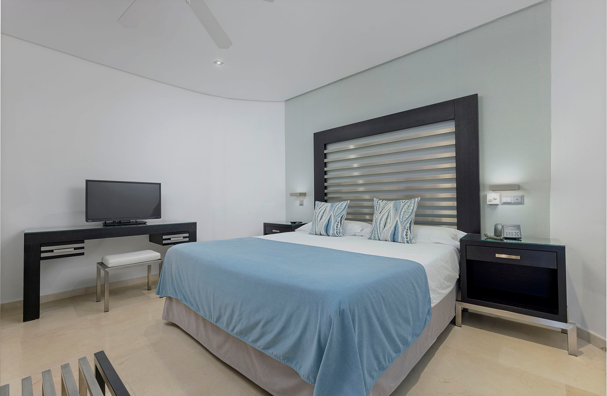 moderne og lyst hotellrom på anfi emirald club med dobbeltseng, skrivebord, tv, nattbord og lys innredning