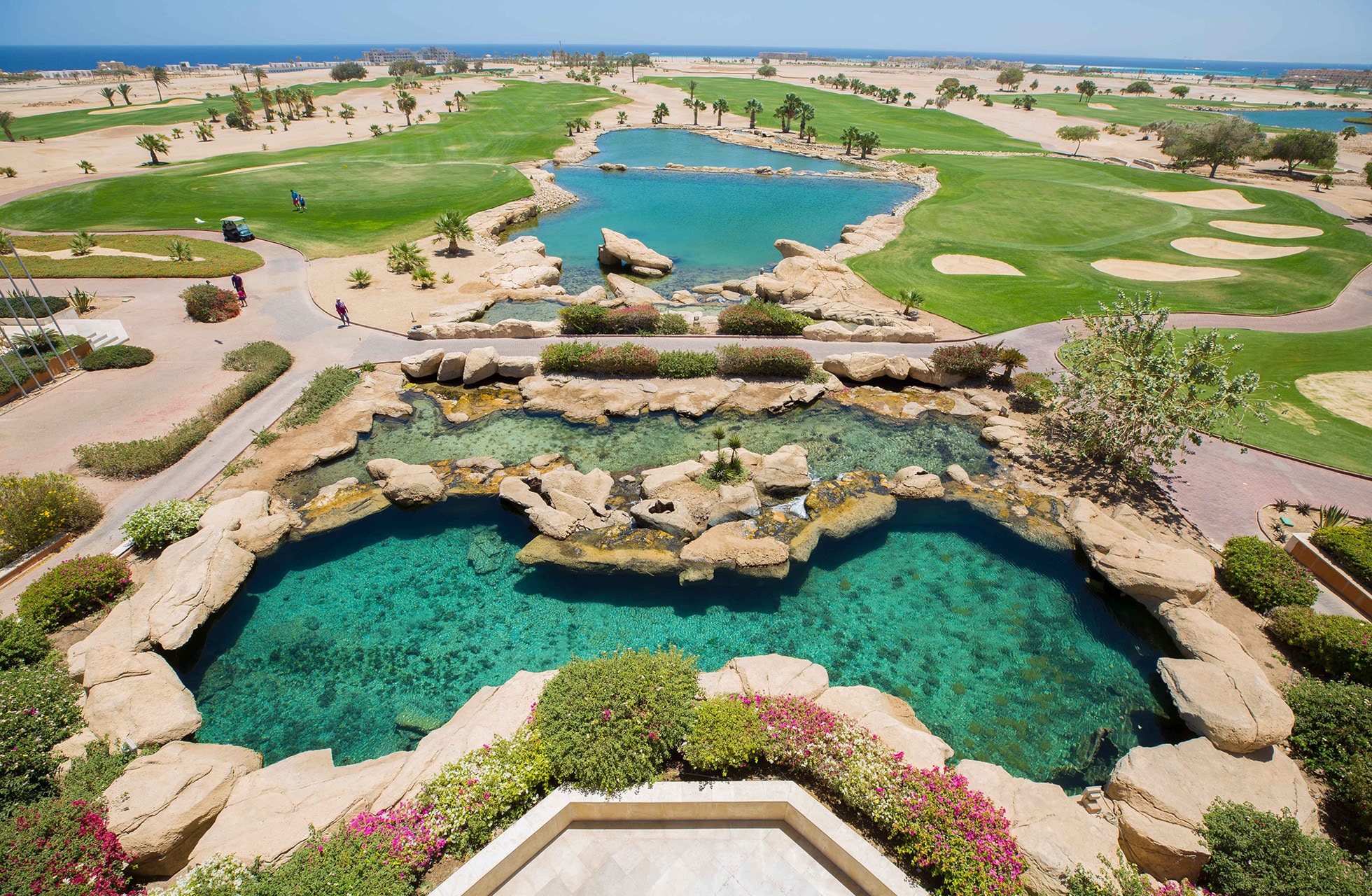 golfbane på soma bay golf med turkise vannpartier, sandformasjoner, greener og ørkenlandskap med havet i bakgrunnen