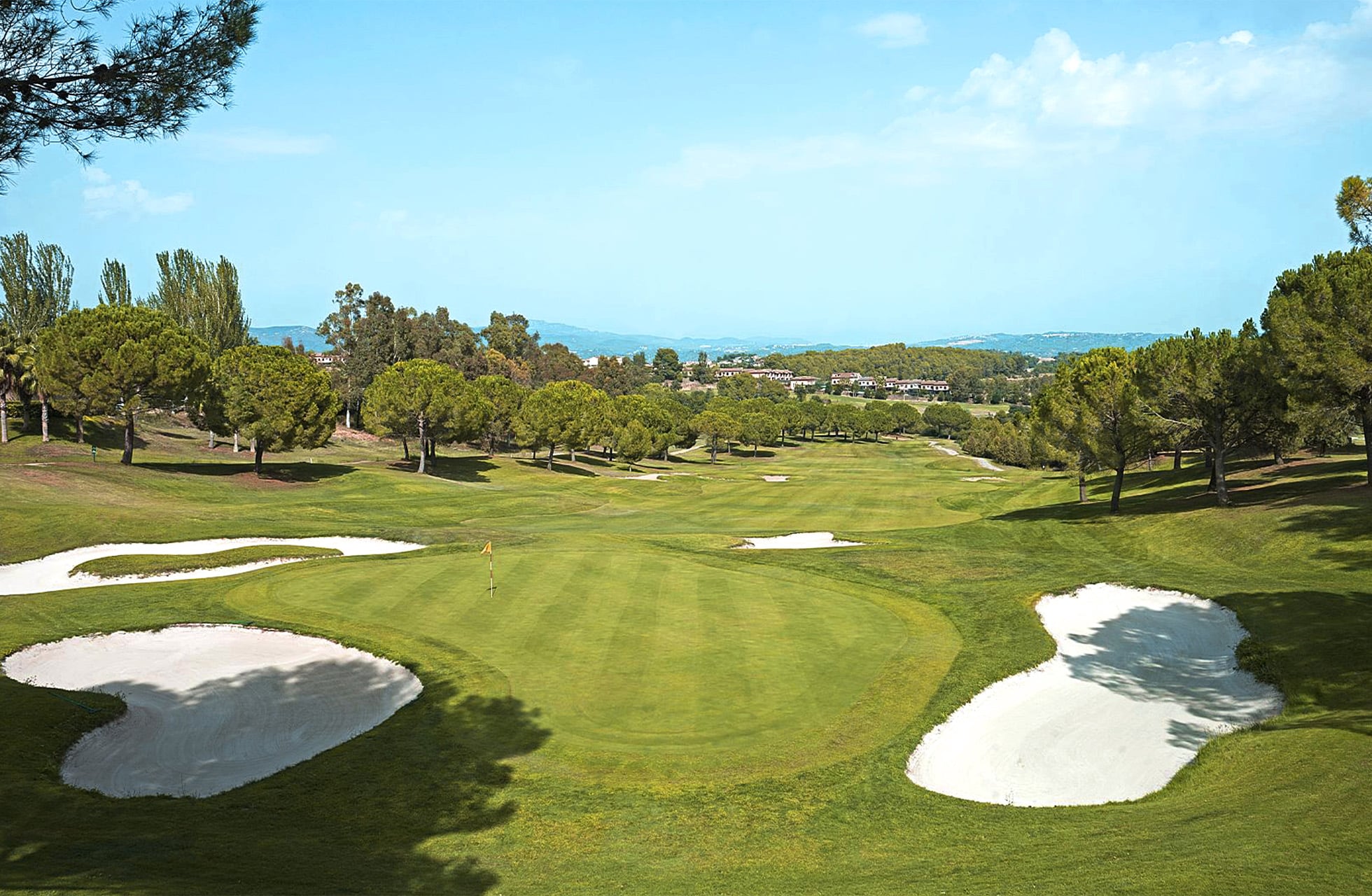 bred fairway omgitt av bunkere og trær