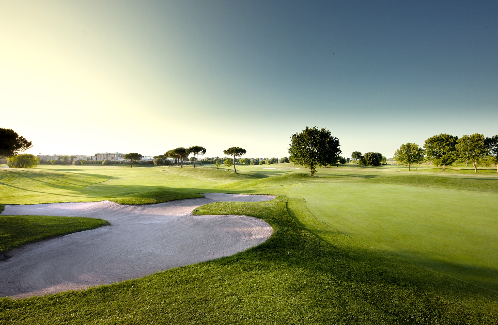 fairway med bunker i mykt morgenlys på parco de’ medici golf club med åpent landskap