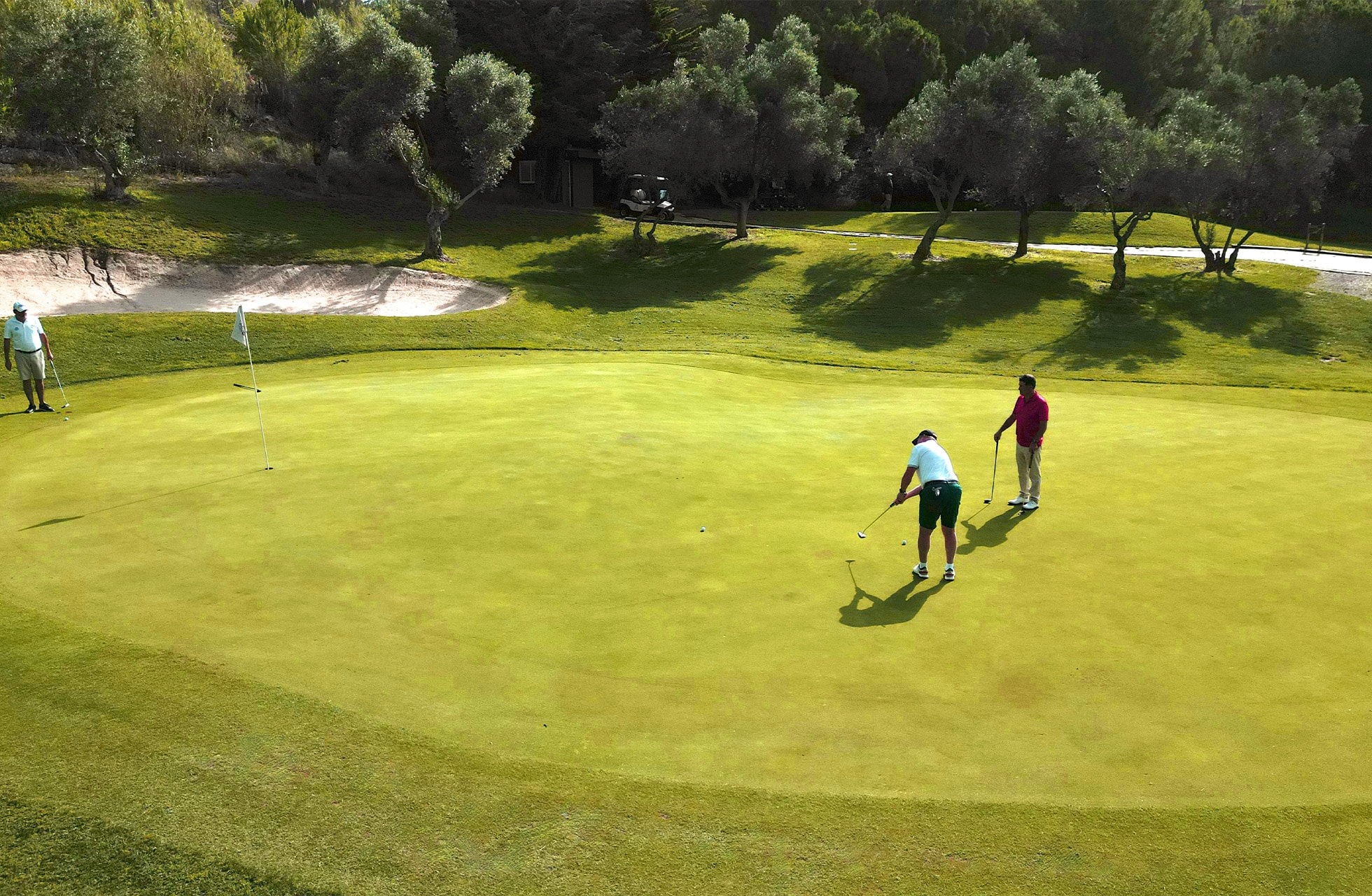 to golfspillere som putter på greenen