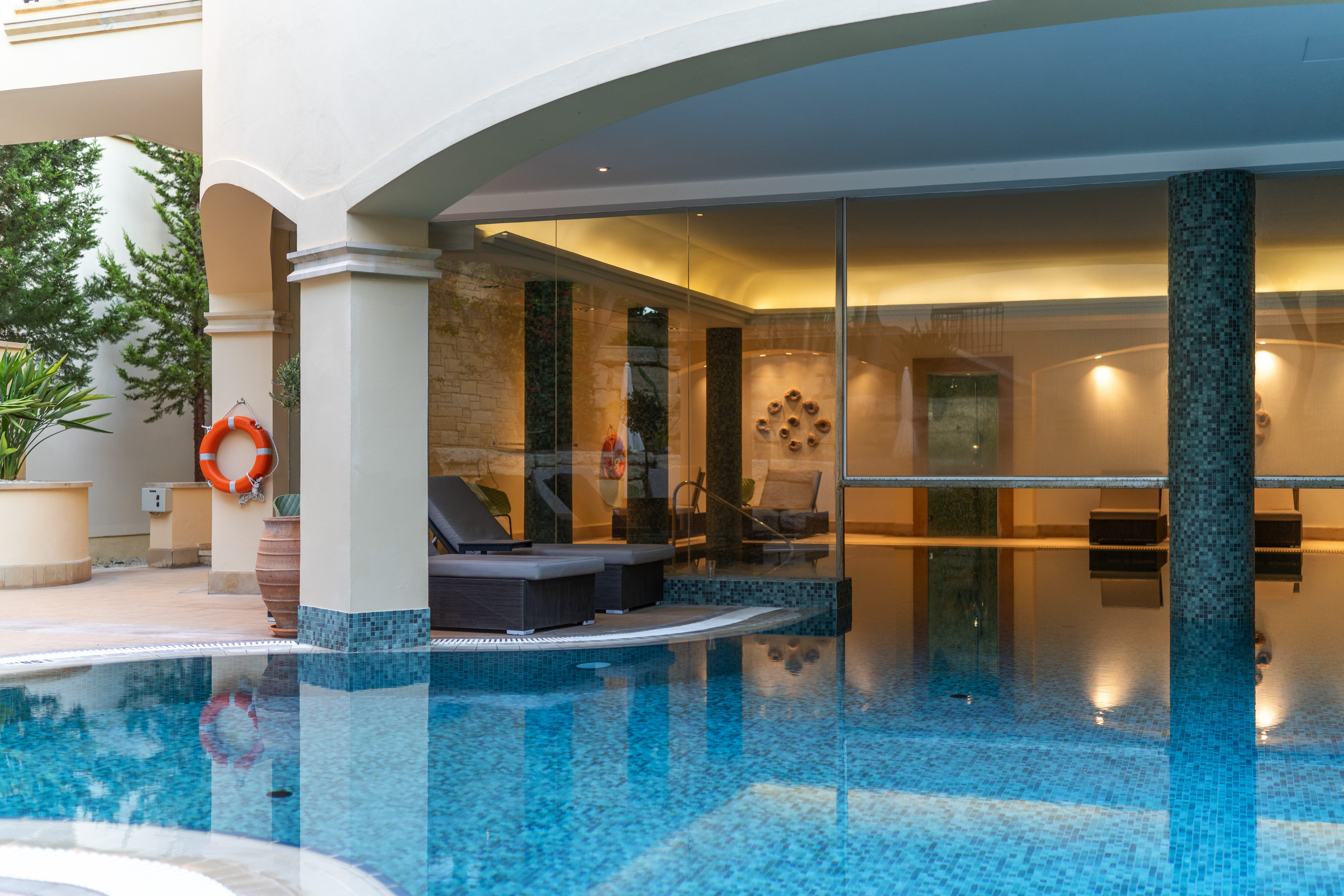 indendørs pool i hotelspa med liggestole, søjler og rolig atmosfære
