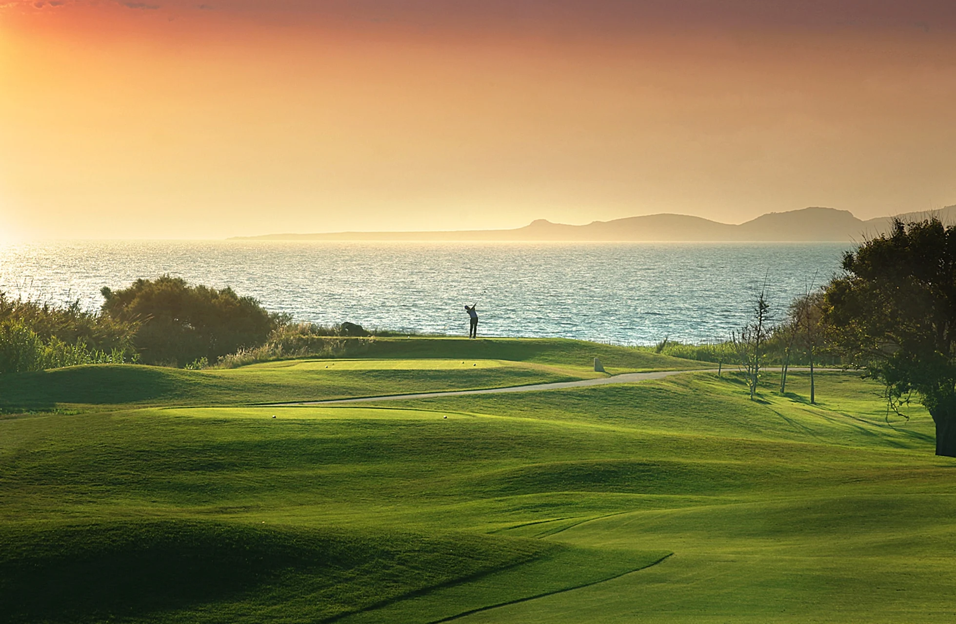 kustnära golfbana i costa navarino med green, hav och mjukt kvällsljus