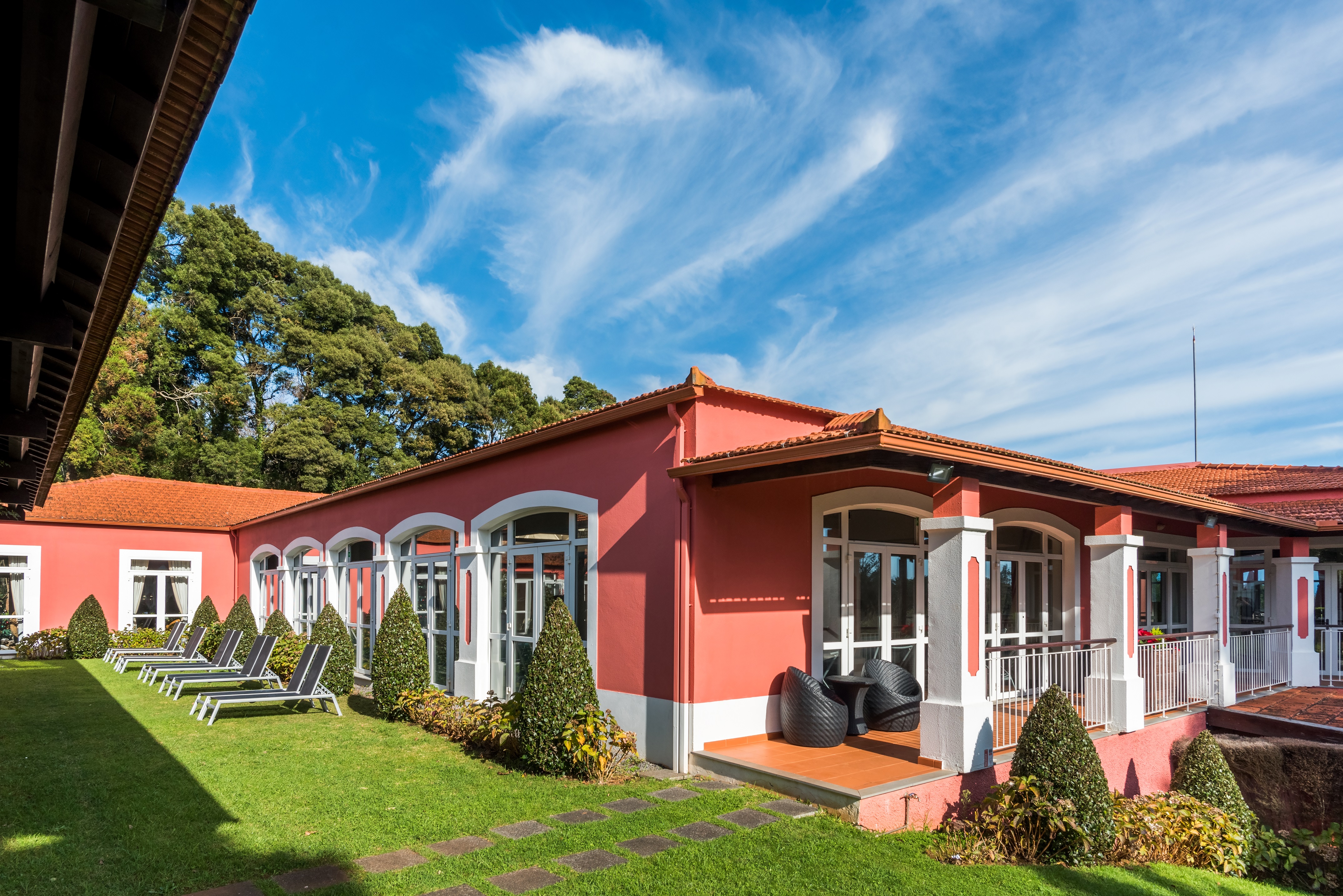 eksteriør av enotel santo da serra med terrasse, solsenger og grønne omgivelser