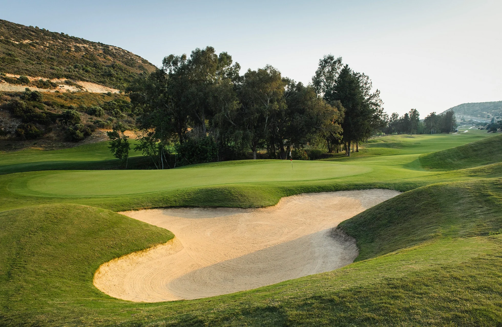 green på secret valley golf club omgitt av bunker og kupert fairway