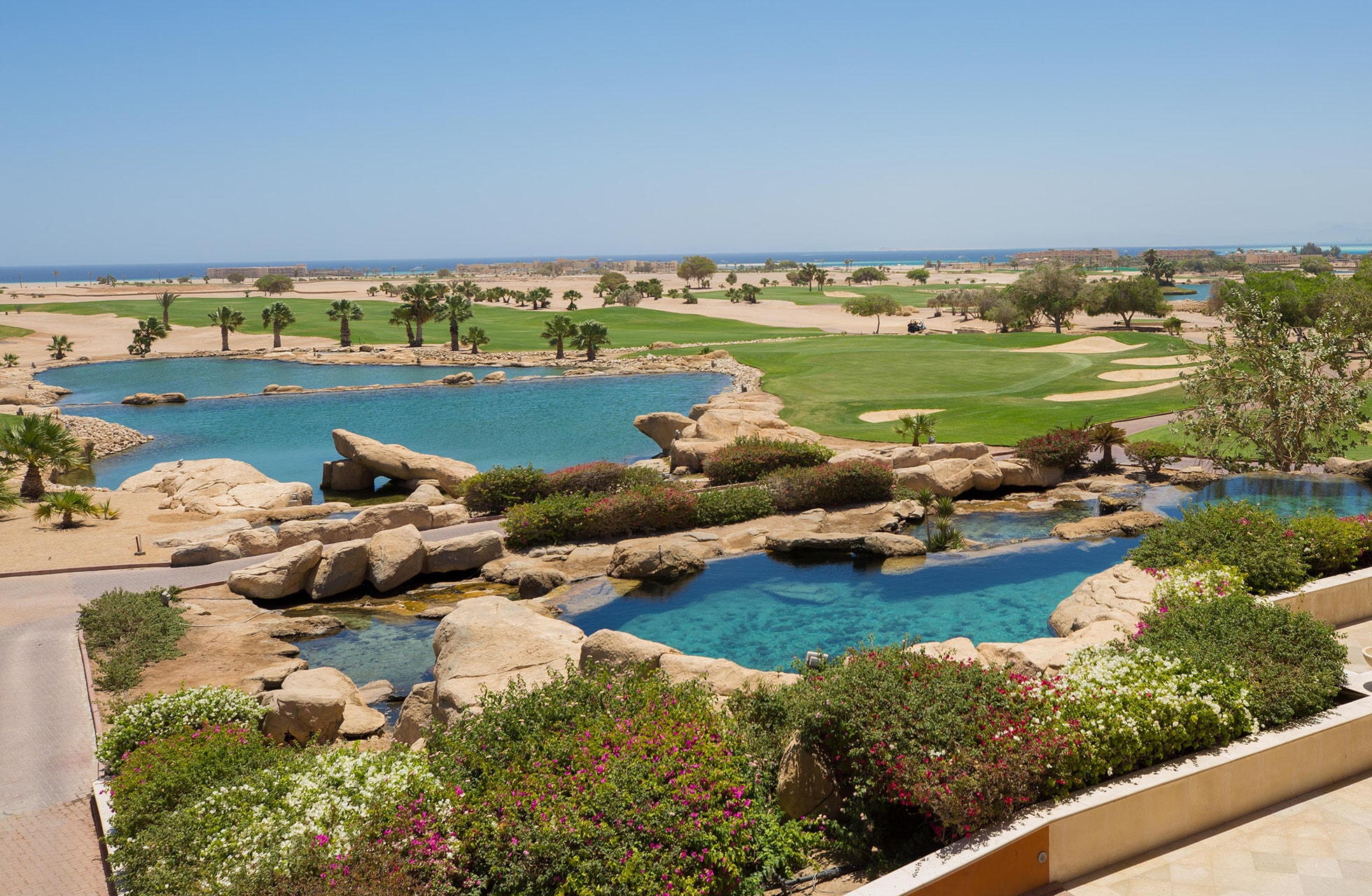 golfbane på soma bay golf med blå vannpartier, sandformasjoner, greener og ørkenlandskap med havet i bakgrunnen