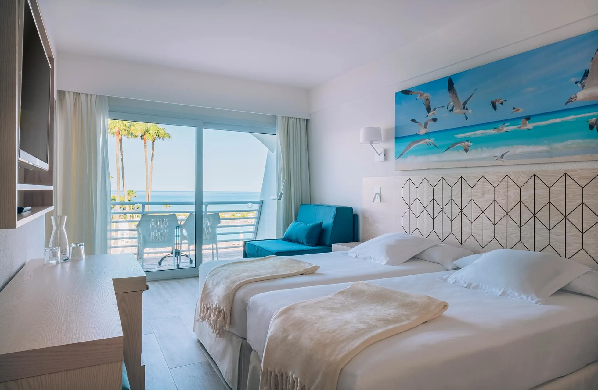 lyst og moderne dobbeltrom på iberostar novo sancti petri med to senger, balkong og utsikt mot havet og palmer