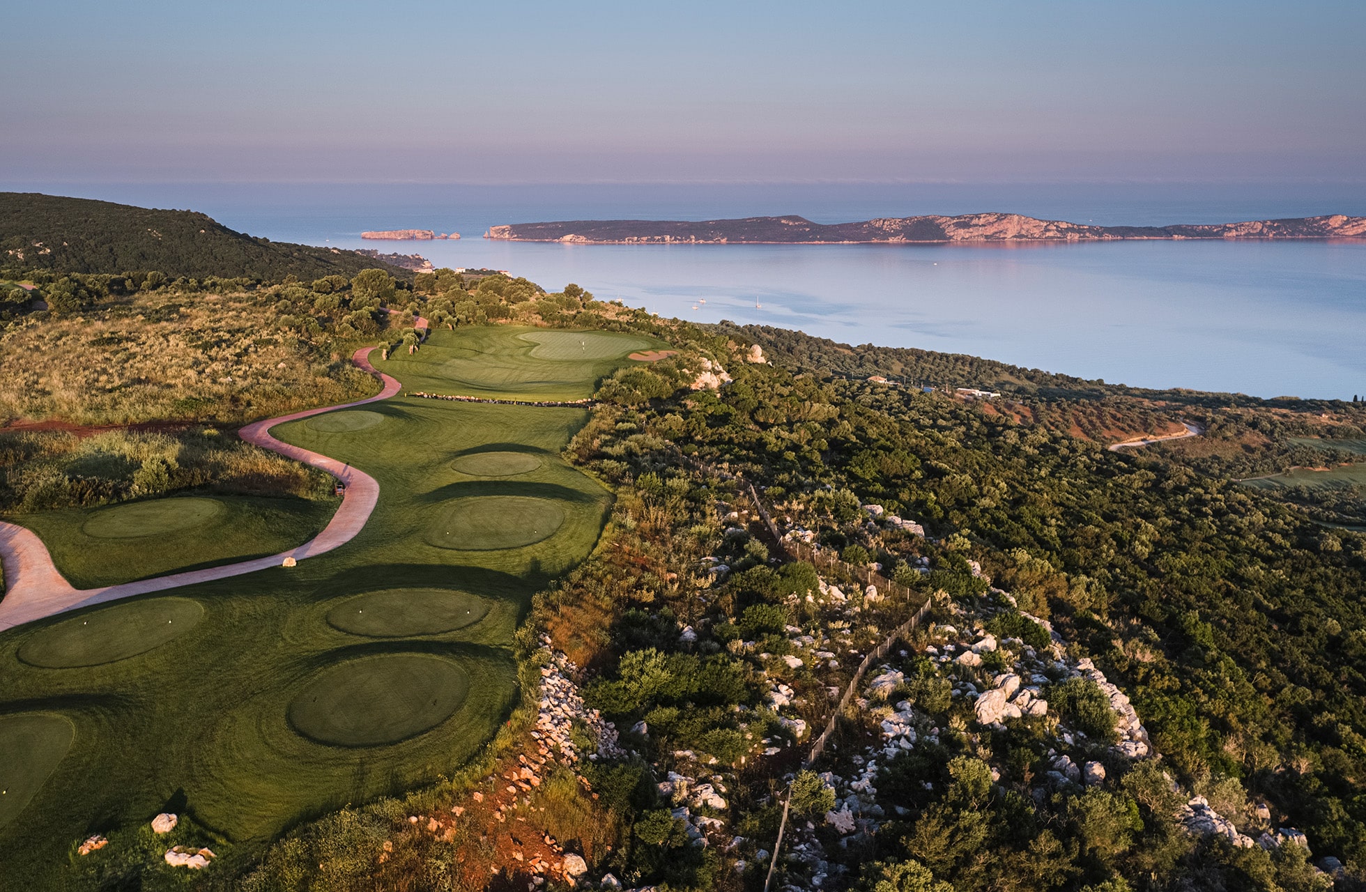 panoramautsikt over flere hull på costa navarino olympic course med svingete golfvei og havutsikt