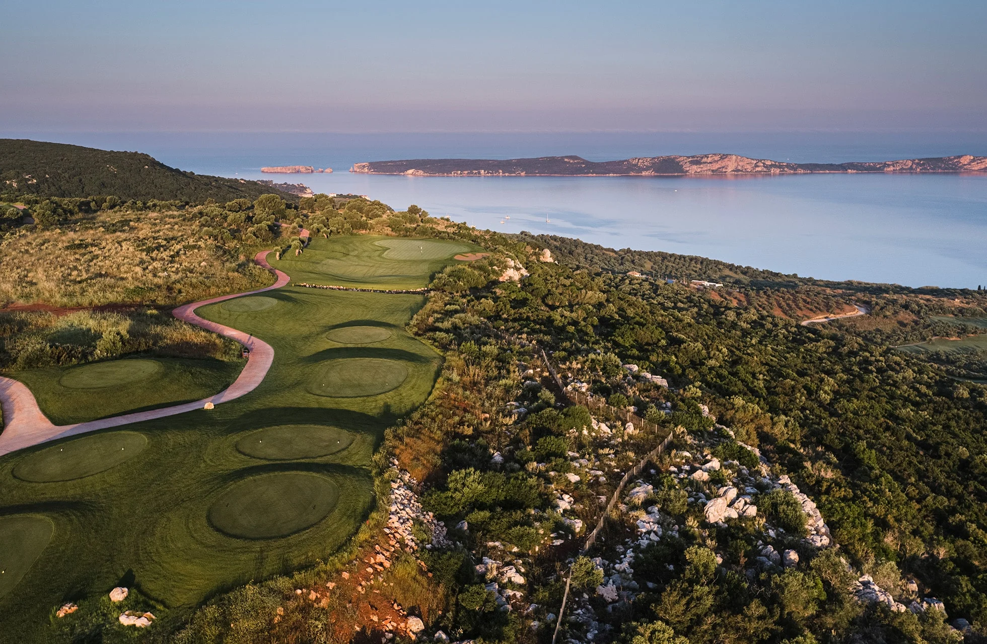 panoramautsikt over flere hull på costa navarino olympic course med svingete golfvei og havutsikt