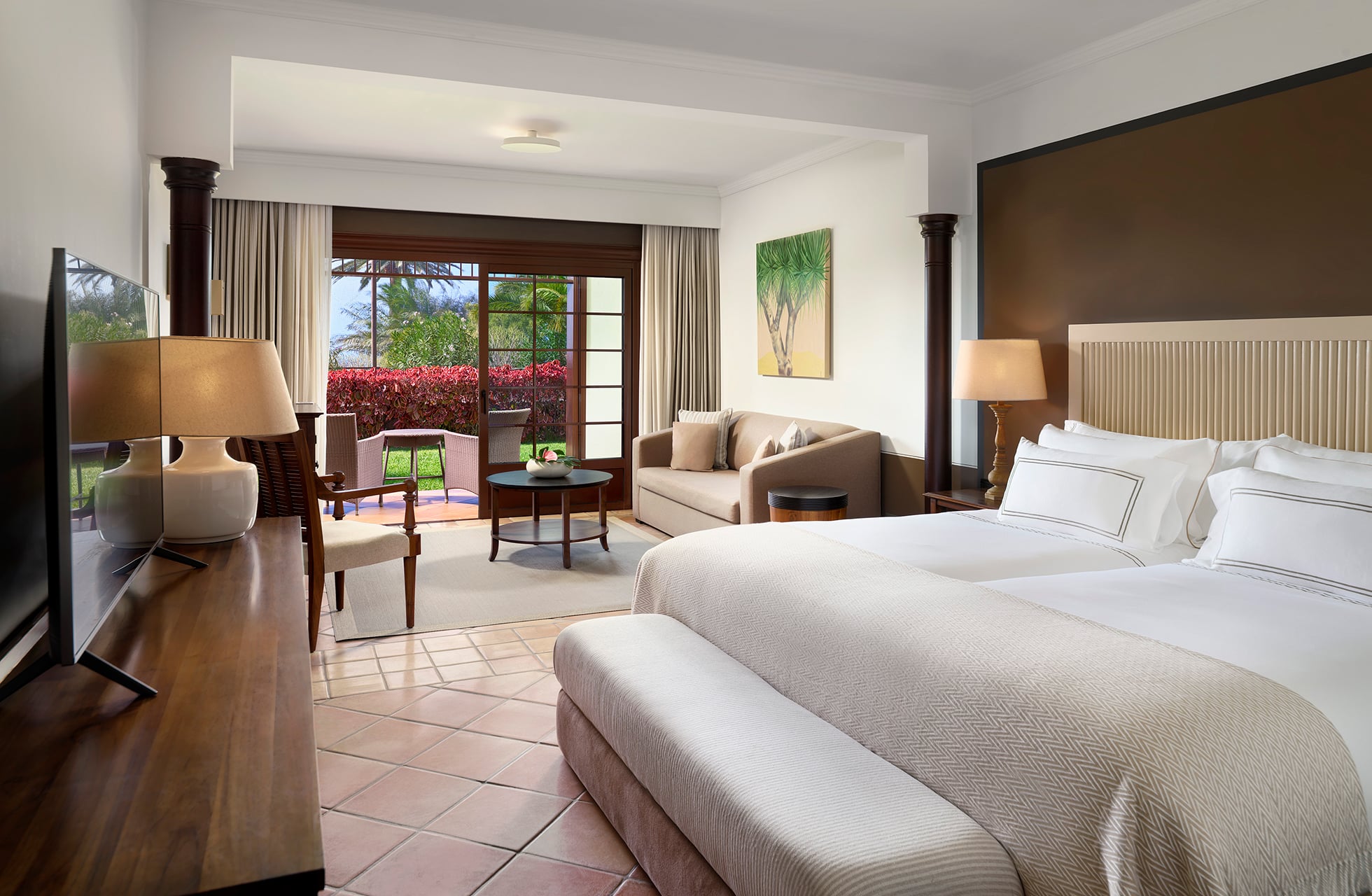 hotellrom på meliá hacienda del conde med dobbeltseng, sittegruppe og utgang til terrasse med grønt utenfor