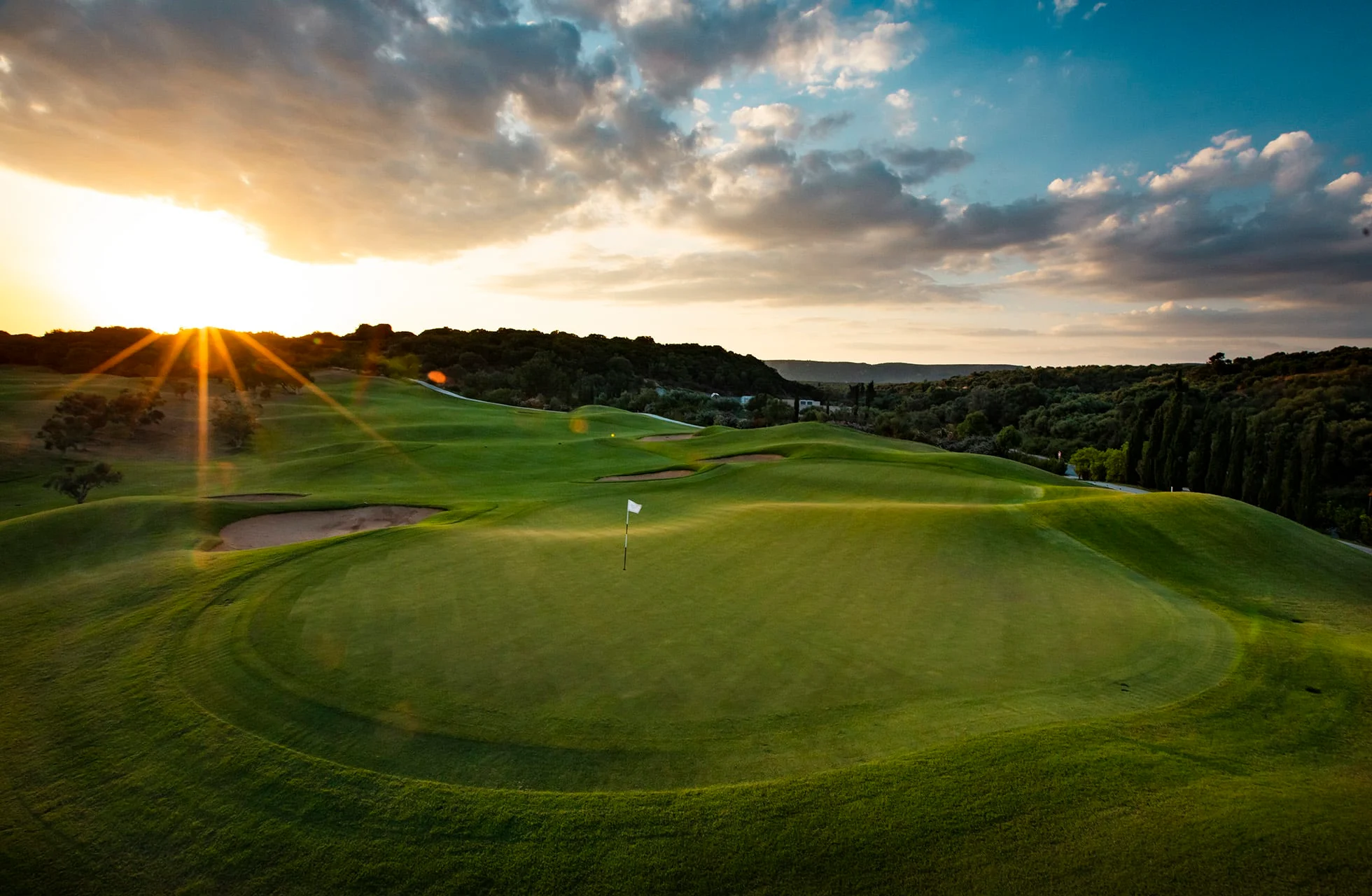 green med flagg på the dunes course costa navarino i solnedgang med bølgende fairwayer
