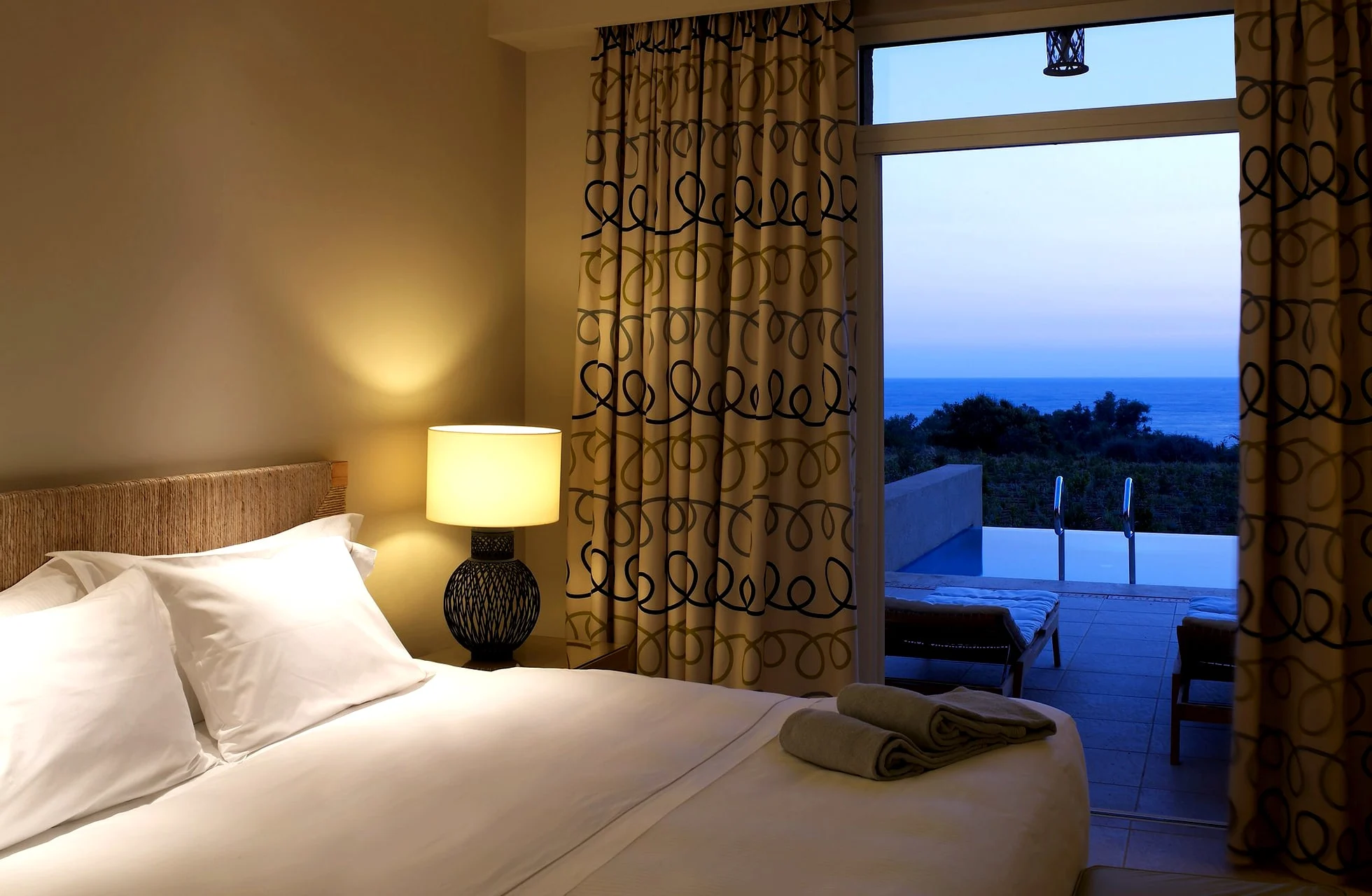 hotellrom på the westin costa navarino med dobbeltseng og uteplass med havutsikt