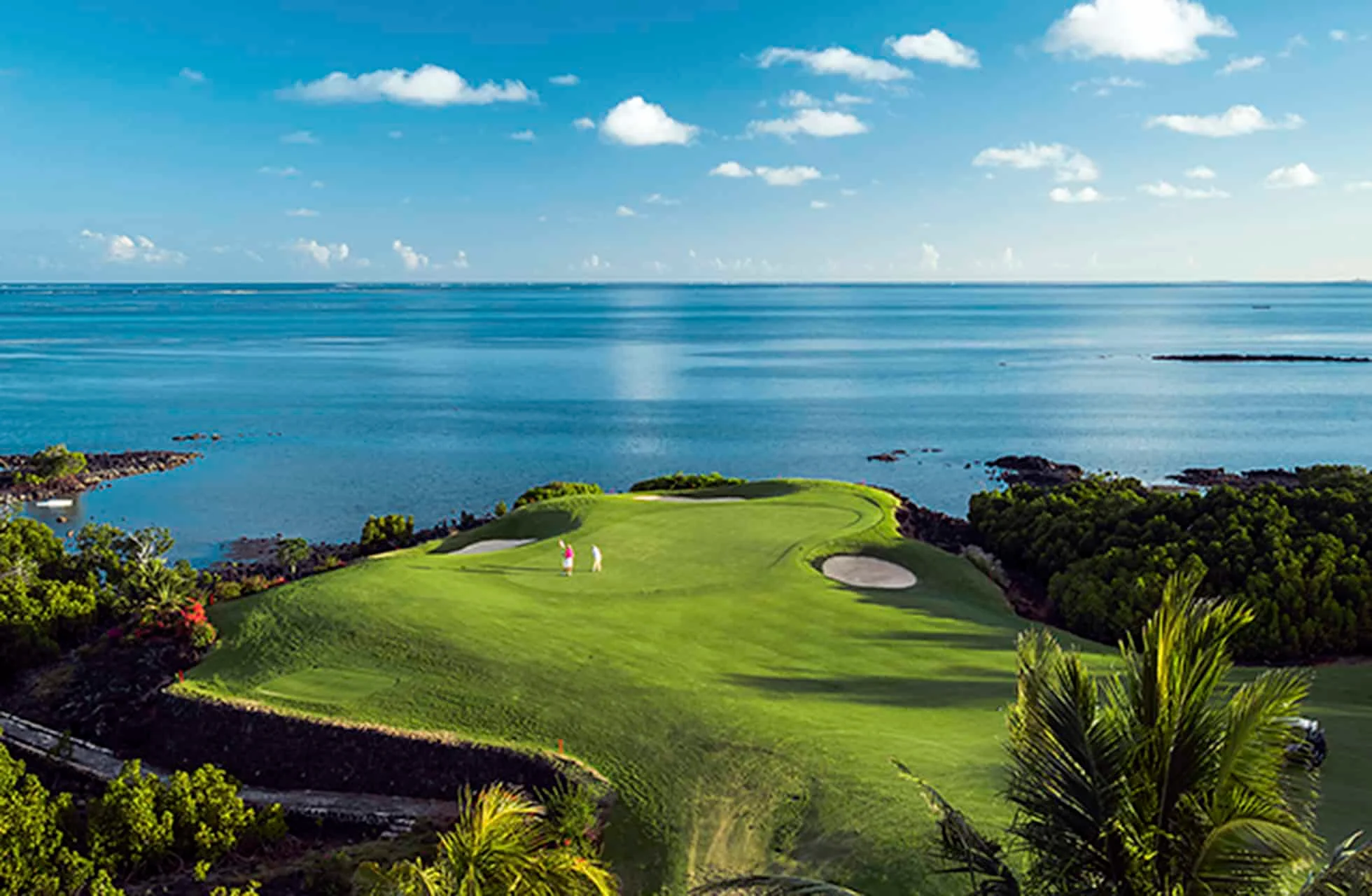 luftfoto af et golfhul på anahita golf club mauritius, hvor green og fairway ligger helt ud til havet omgivet af tropisk beplantning