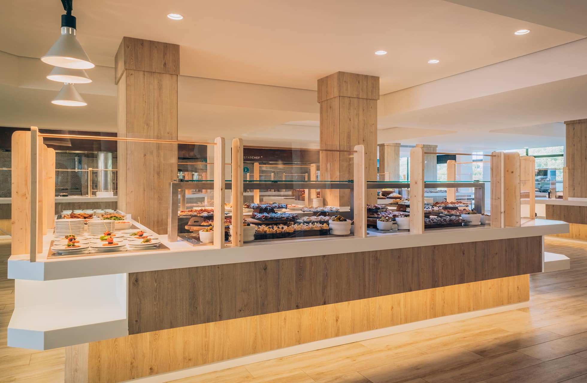 Bufféstasjon med oppsatte tallerkener og glassutstillinger i hotellrestauranten.