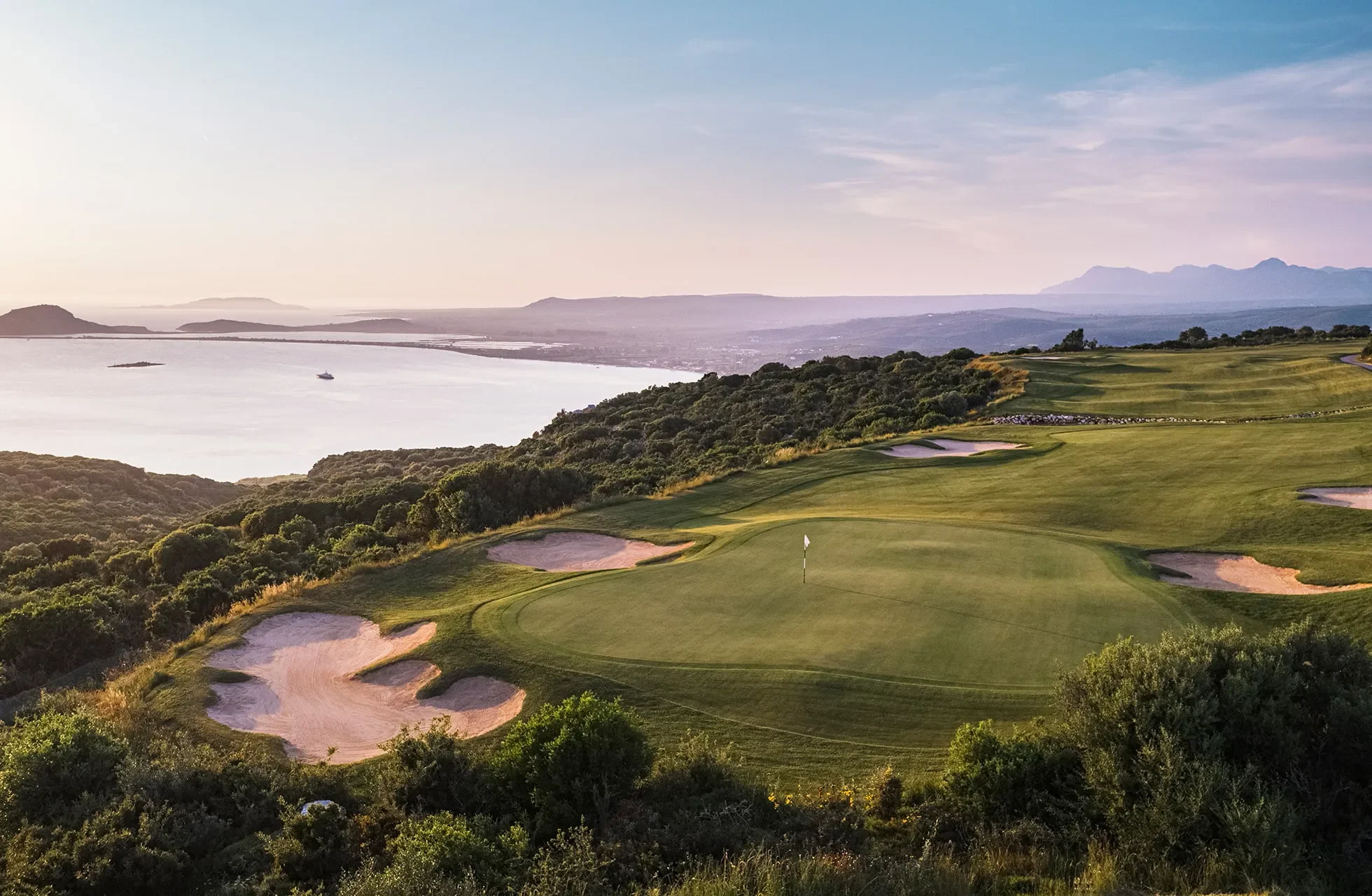 hevet green på costa navarino olympic course med bunkere og kystlinje i kveldslys