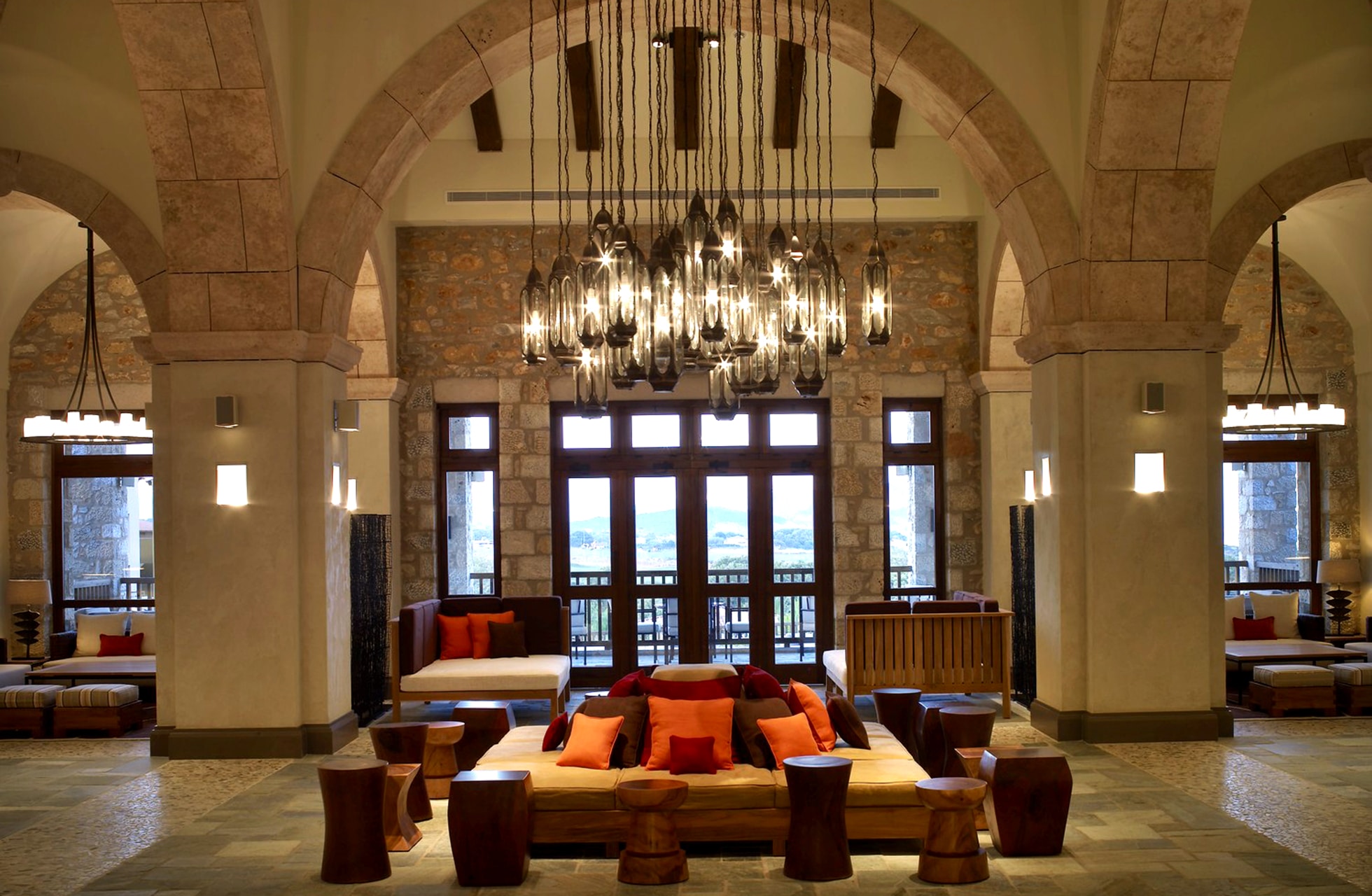 romslig lobby på the westin costa navarino med steinbuer, store lysekroner og sittegrupper