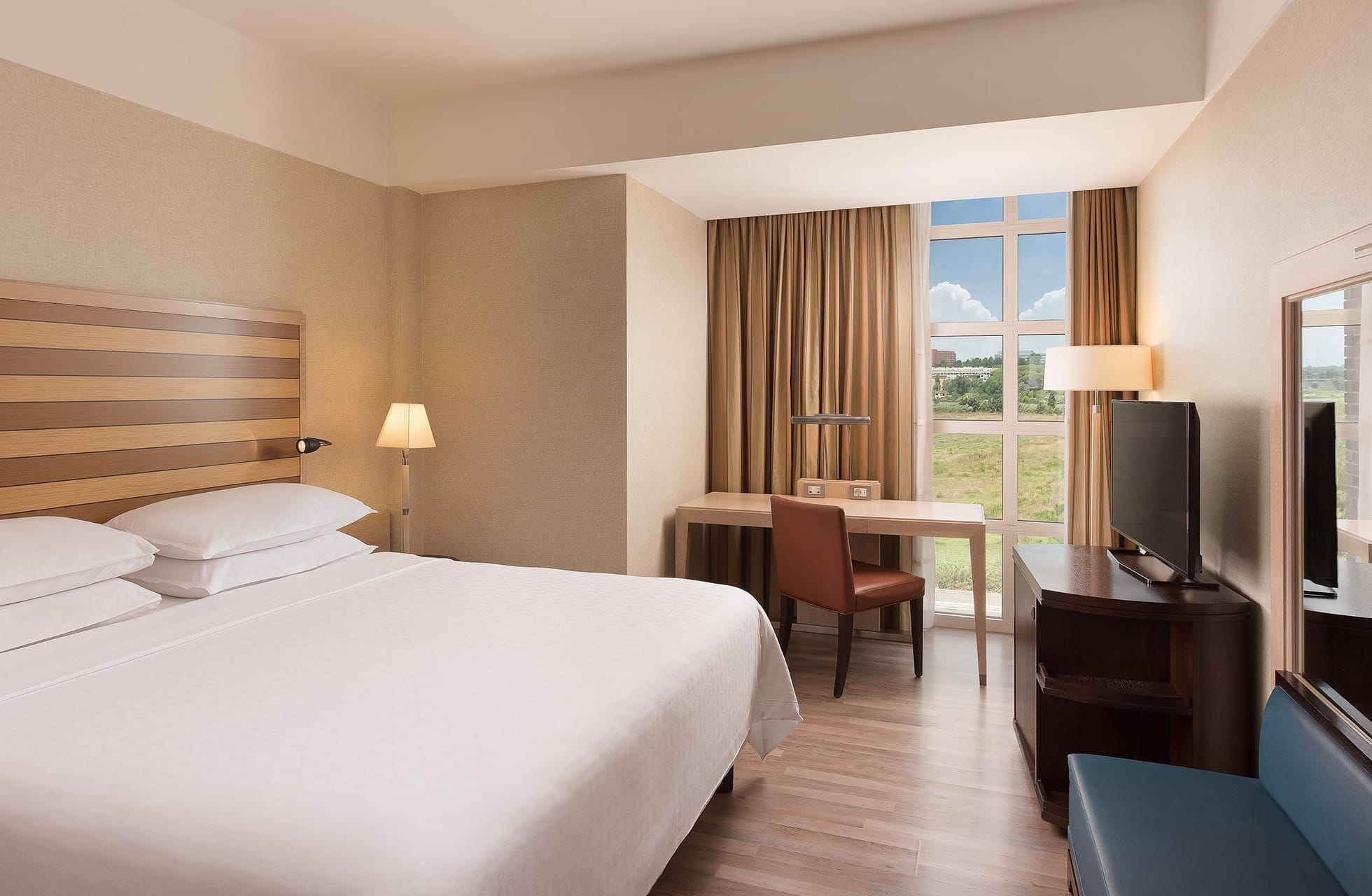 lyst hotellrom med dobbeltseng, skrivebord og vindu med utsikt mot grøntområde ved parco de’ medici