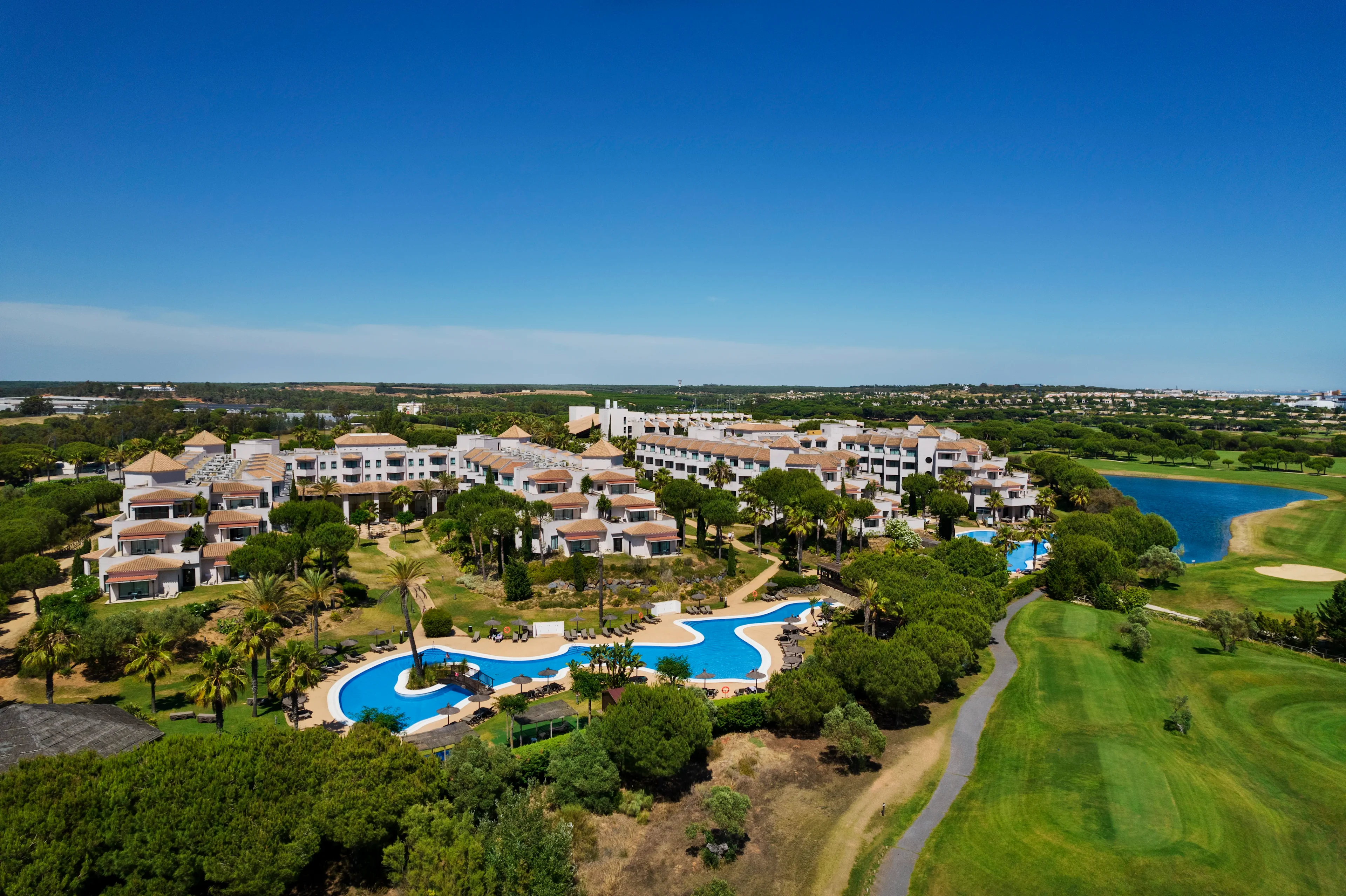 ilmakuva precise resort el rompido the club -hotellista, uima-allasalueista ja ympäröivästä golfkentästä vehreässä maisemassa.
