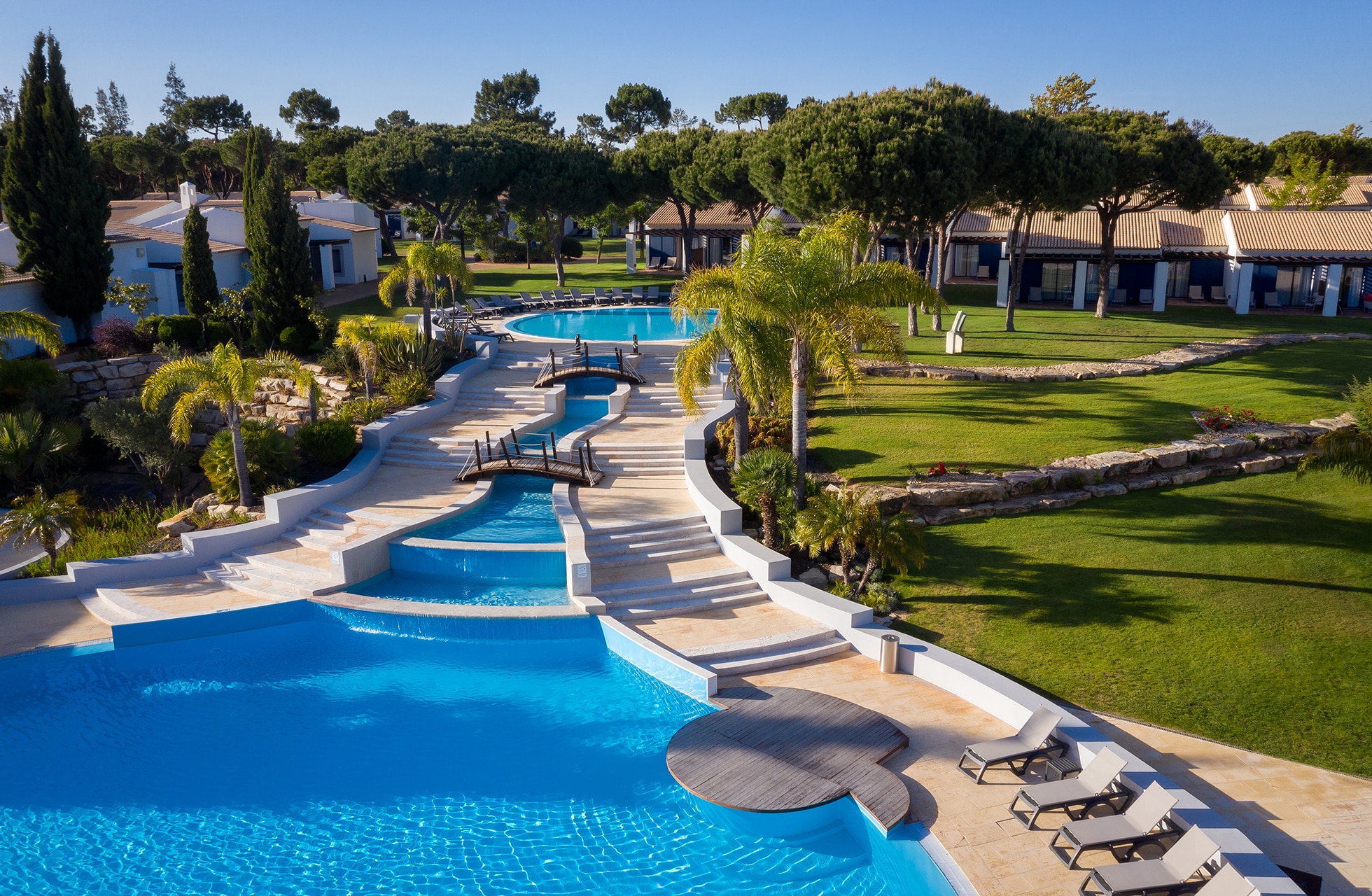 bassengområde ved vila sol resort med flere sammenhengende bassenger, solsenger og palmer i grønne og rolige hotellomgivelser ved golfbanen