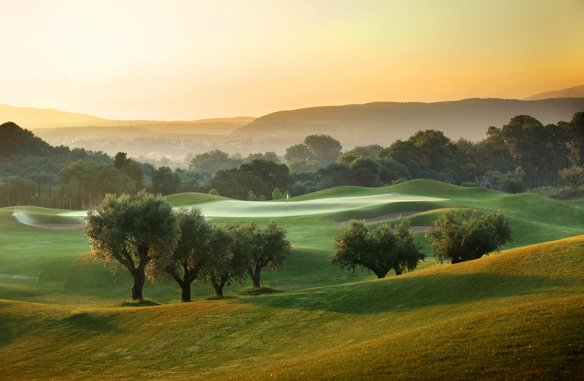 bølgende golfbane på the dunes course, costa navarino, omgitt av oliventrær i varmt kveldslys