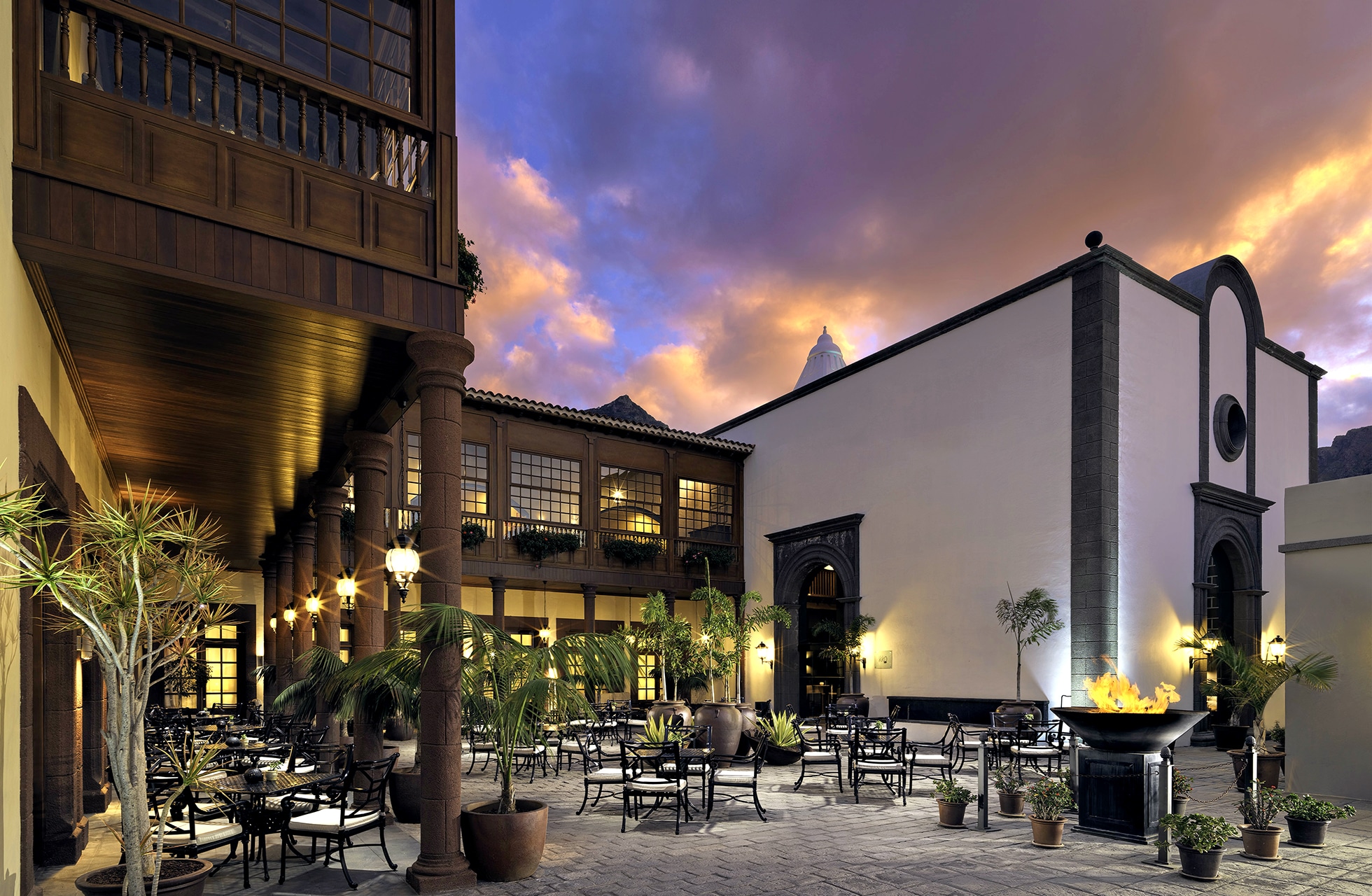 gårdsrom på meliá hacienda del conde med uteservering, bord og stoler, planter og historisk arkitektur i kveldslys