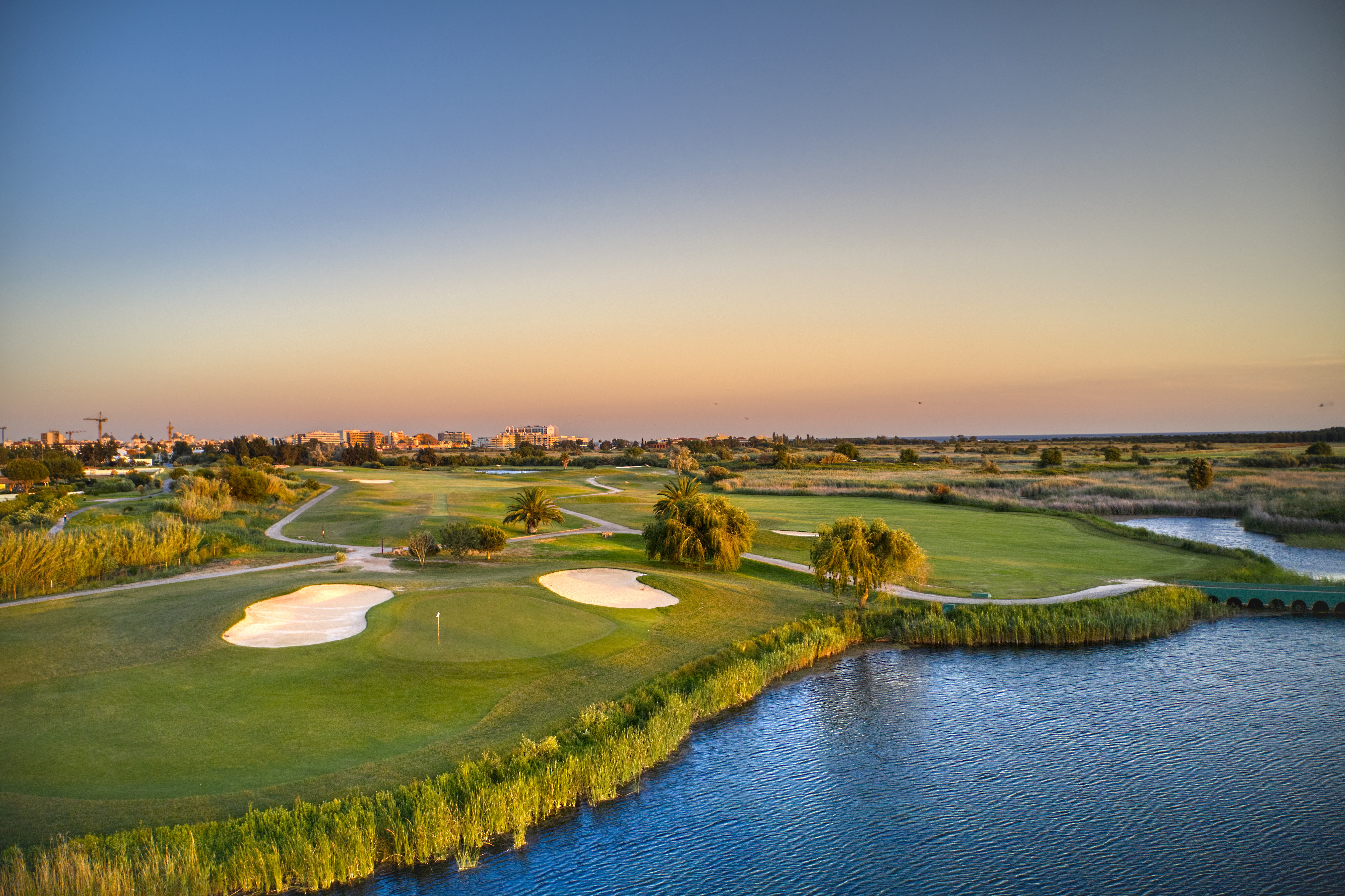 näkymä viheriölle ja bunkkereille vilamoura laguna golf coursella veden äärellä lämpimässä iltavalossa