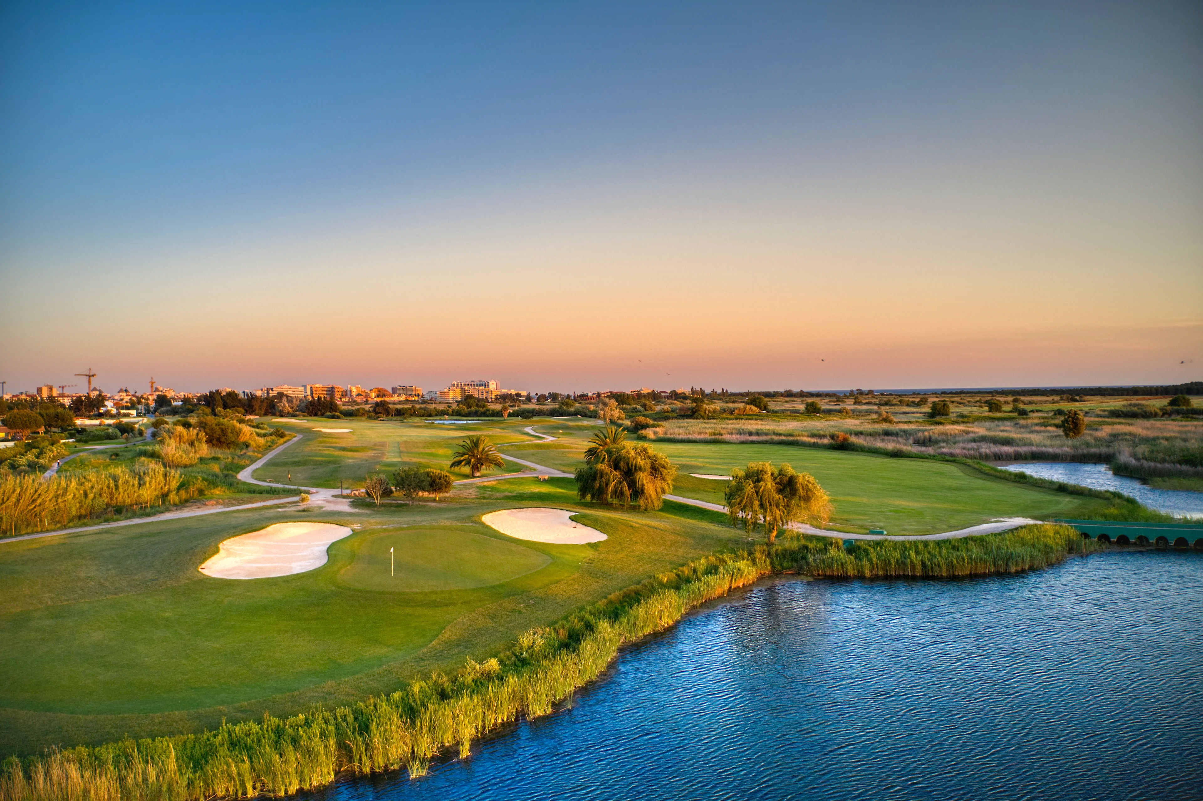 näkymä viheriölle ja bunkkereille vilamoura laguna golf coursella veden äärellä lämpimässä iltavalossa