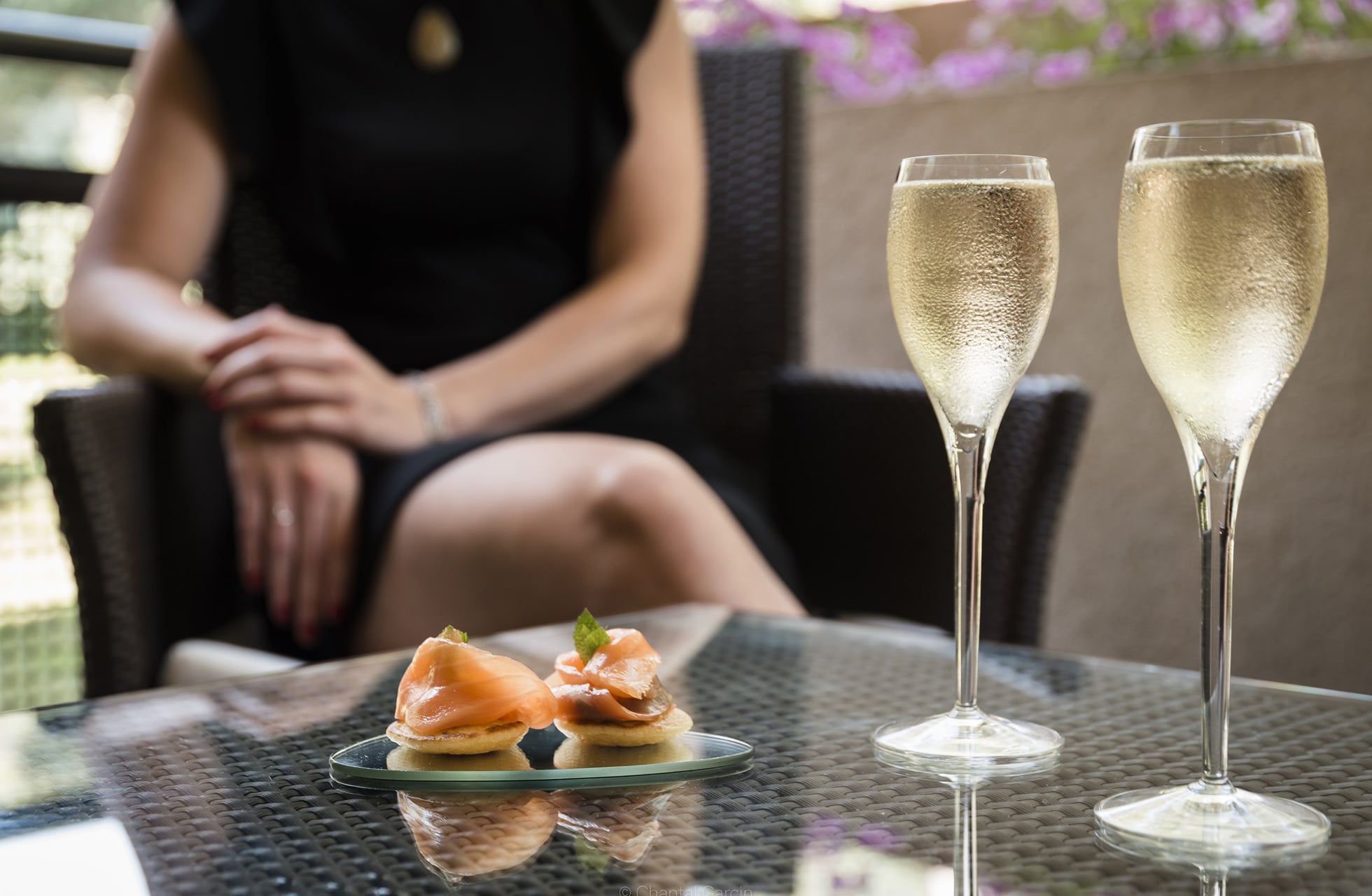 to glass musserende vin og små anretninger på bord på terrasse i avslappende atmosfære