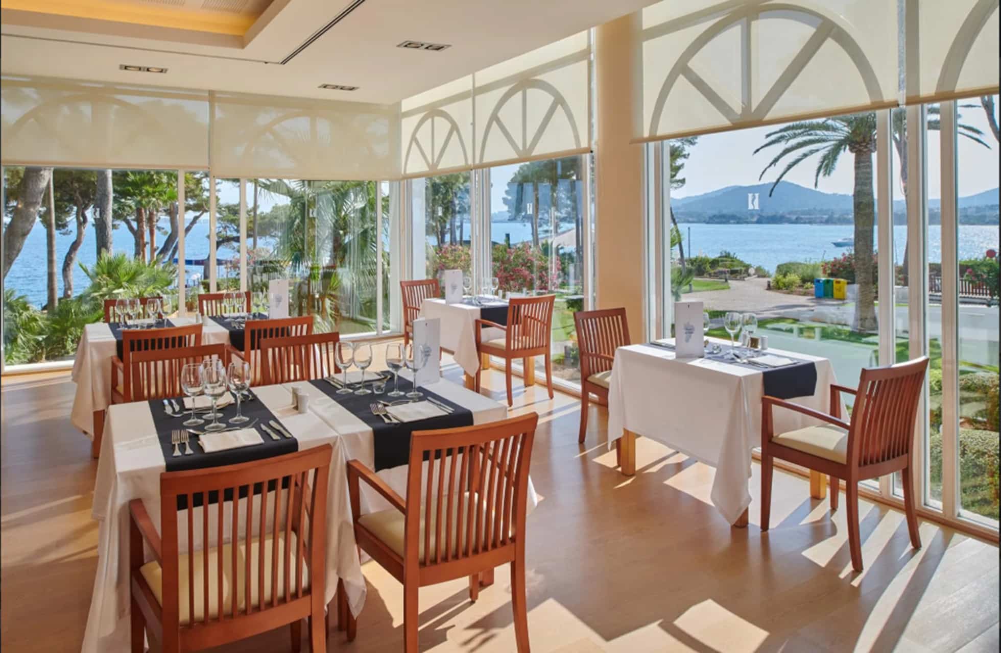 lys hotellrestaurant på eurotel punta rotja med dekkede bord, store vinduer og utsikt mot palmer, grøntområder og hav i dagslys