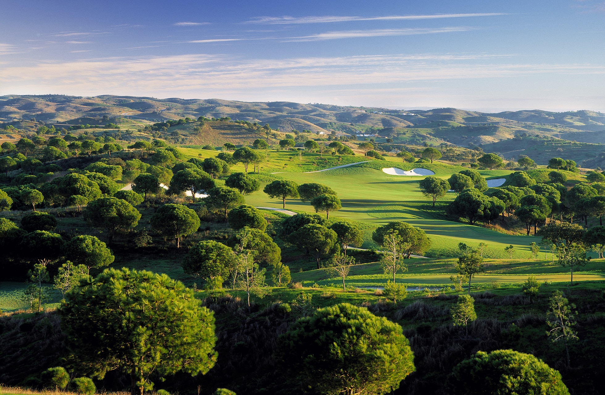 panoramautsikt over monte rei golf club i algarve med bølgende fairwayer, greener og naturlig landskap i kupert terreng