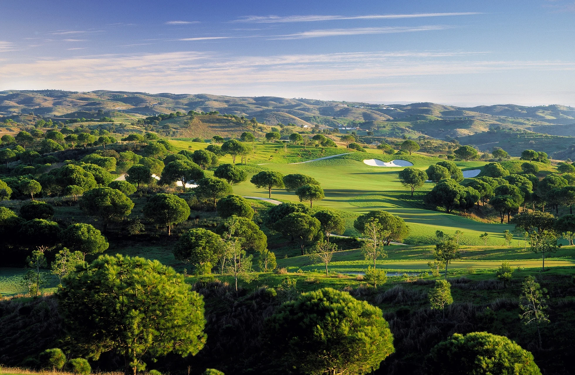 panoramautsikt over monte rei golf club i algarve med bølgende fairwayer, greener og naturlig landskap i kupert terreng