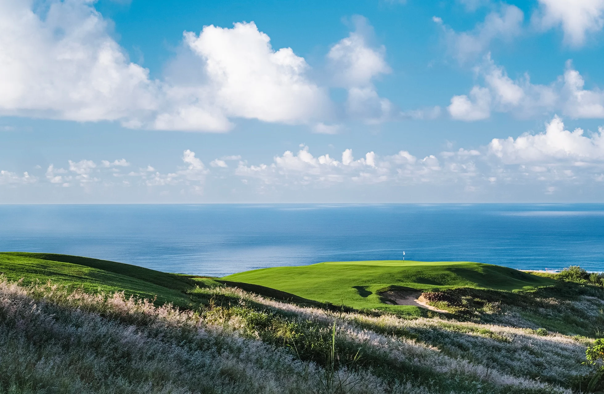 kystnær linksbane på heritage golf club la réserve golf links med grønne spilleflater på høyde og åpent hav i bakgrunnen