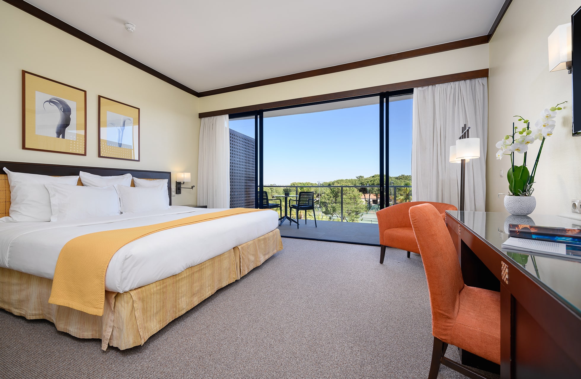 lyst og moderne deluxe golfrom på vila sol resort med dobbeltseng, skrivebord og balkong med utsikt over golfbane og grønne omgivelser