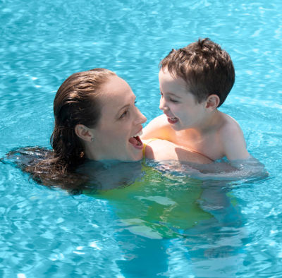 Woman and young boy swim in an eco-friendly swimming pool