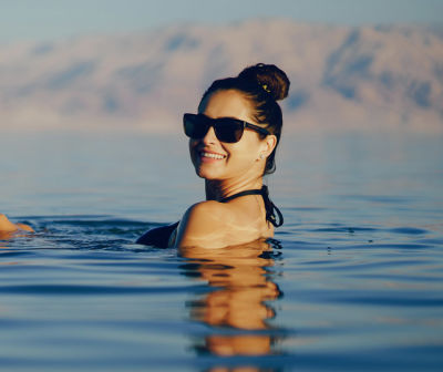 Woman floating in Dead Sea magnesium-rich minerals without chlorine
