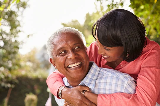 A couple in their 50s are smiling confidently thanks to Fixodent discussing "What are Immediate Dentures?"